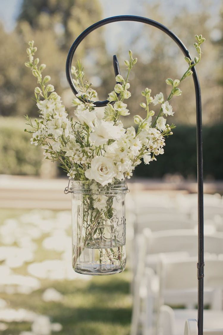 Line the aisle with flowers hanging from Dollar Tree shepherds hooks.