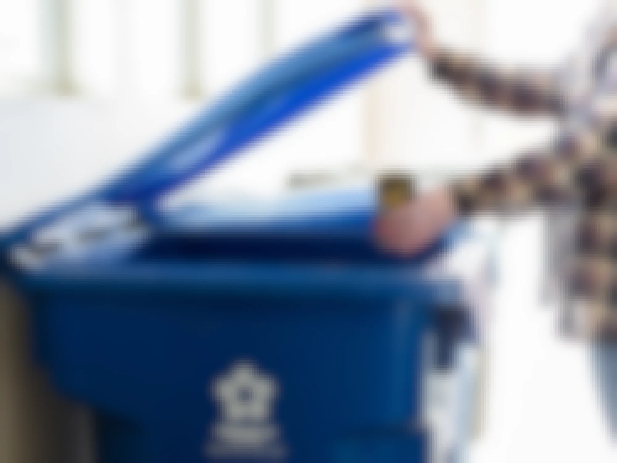 a person recycling cans into a recycling bin 