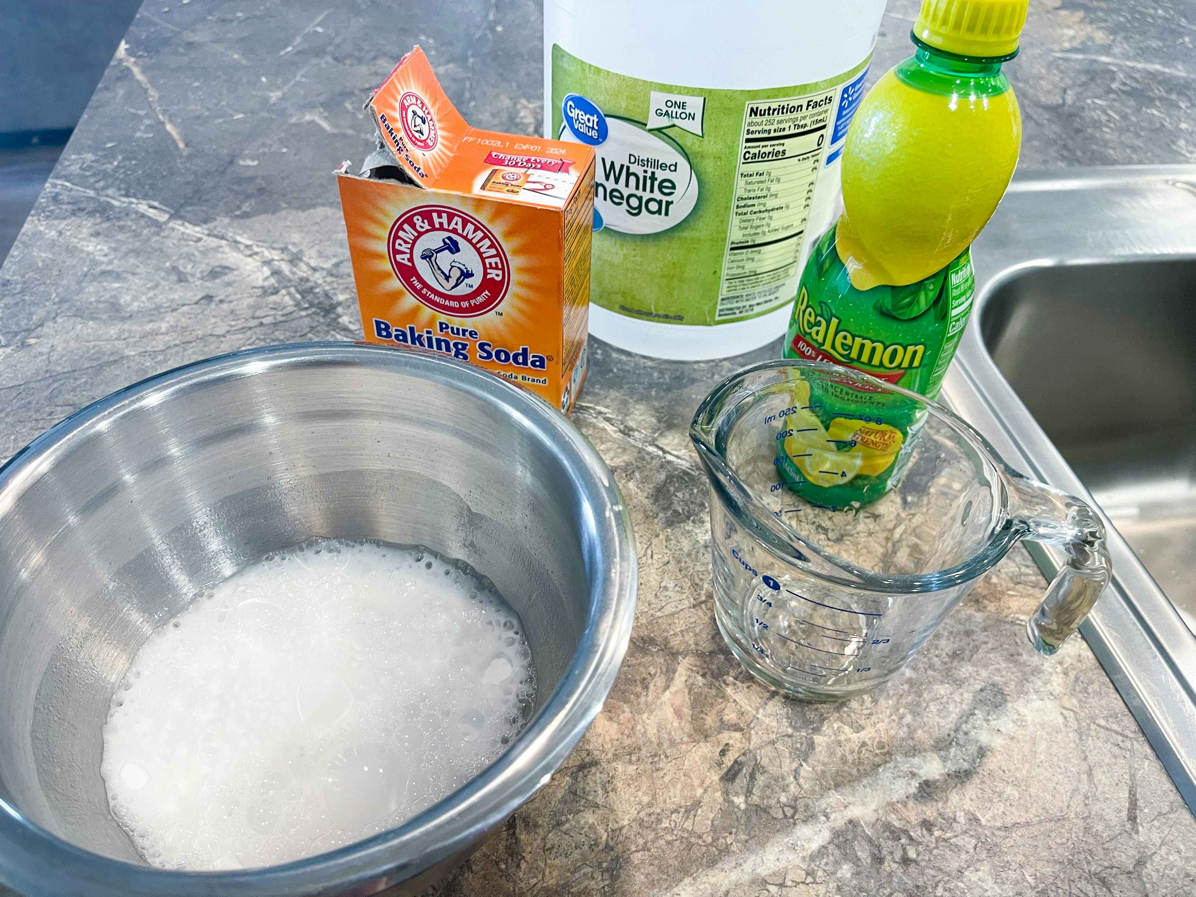 bowl with baking soda, vinegar, and lemon juice on counter