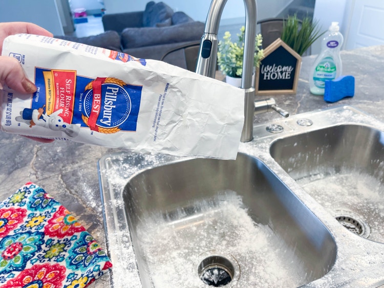 person pouring flour in sink