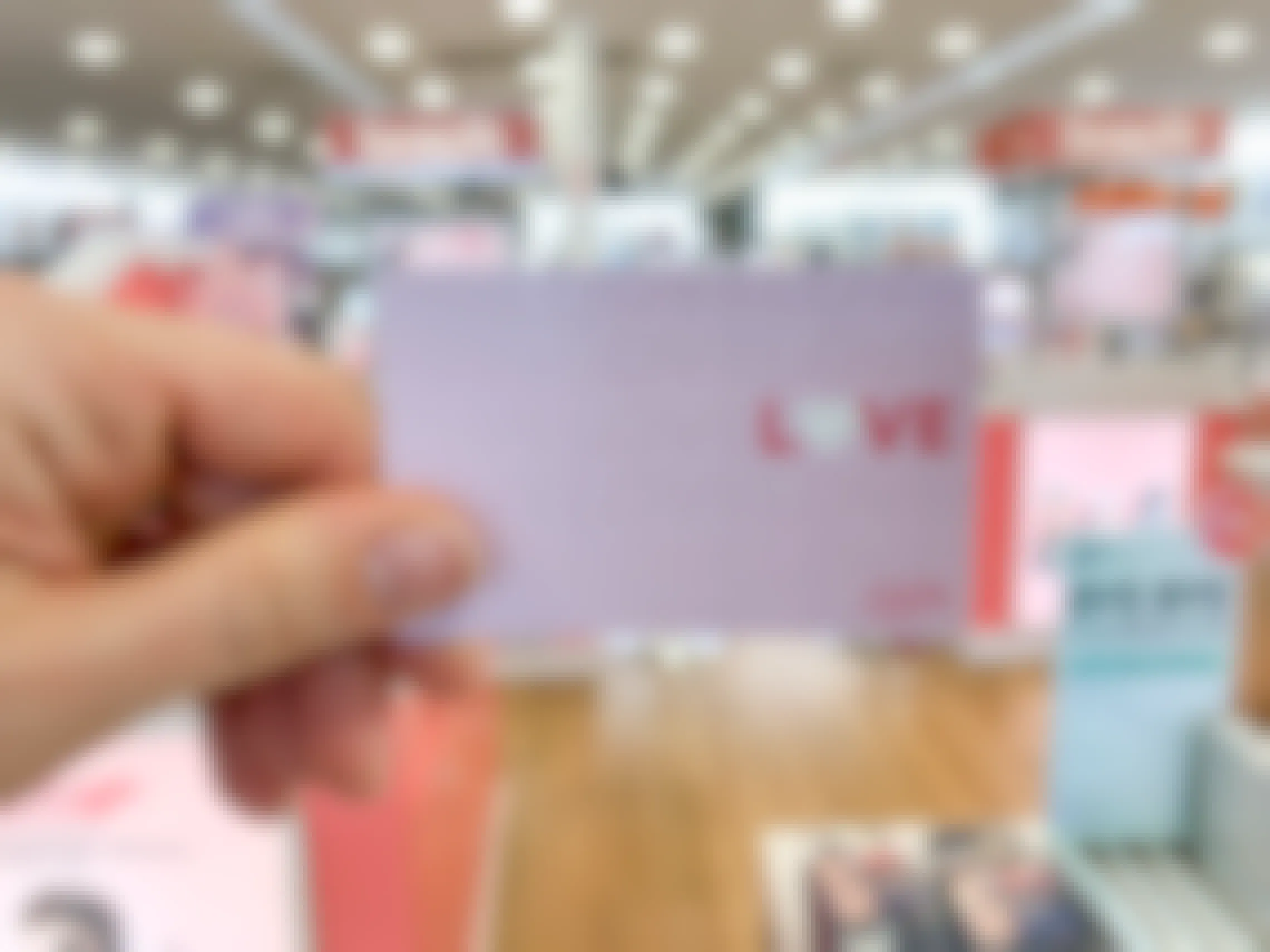 An ulta gift card with the word "Love" on the front held in a store.
