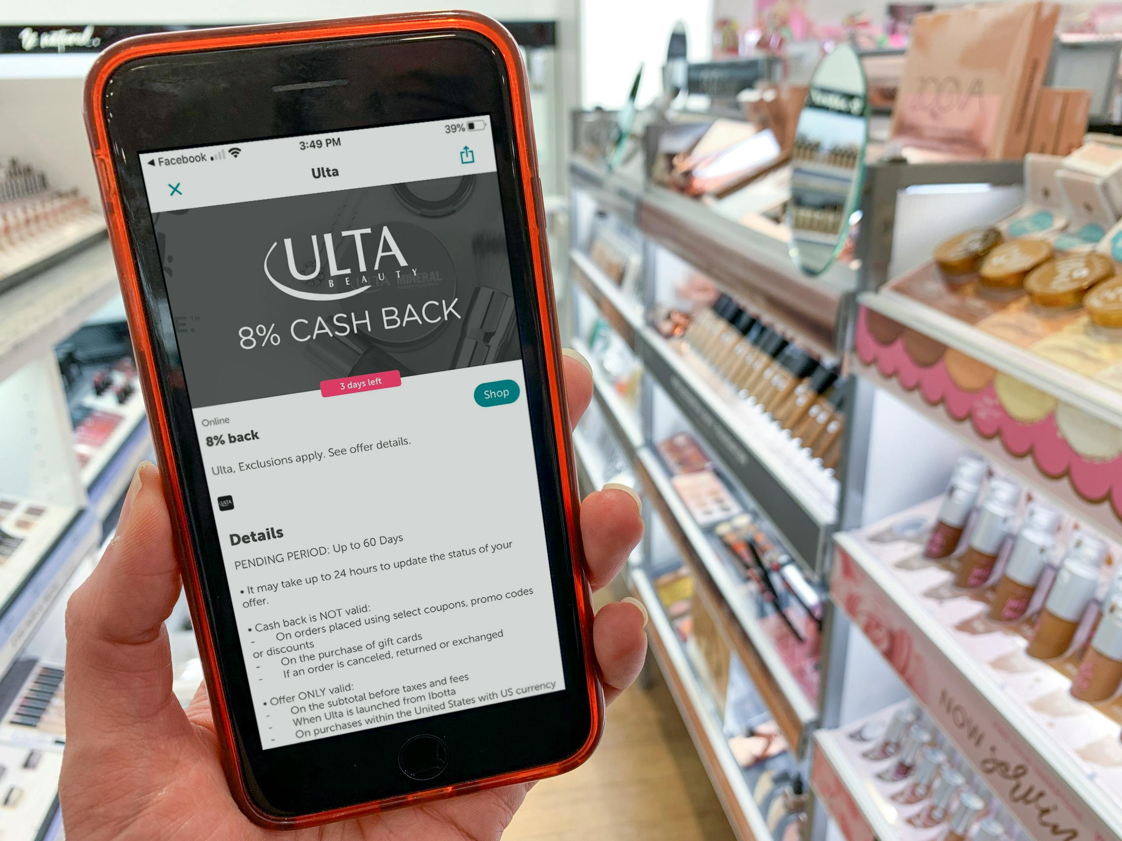 Hand holds smart phone with screen showing Ibotta app and 8% cash back for ULTA