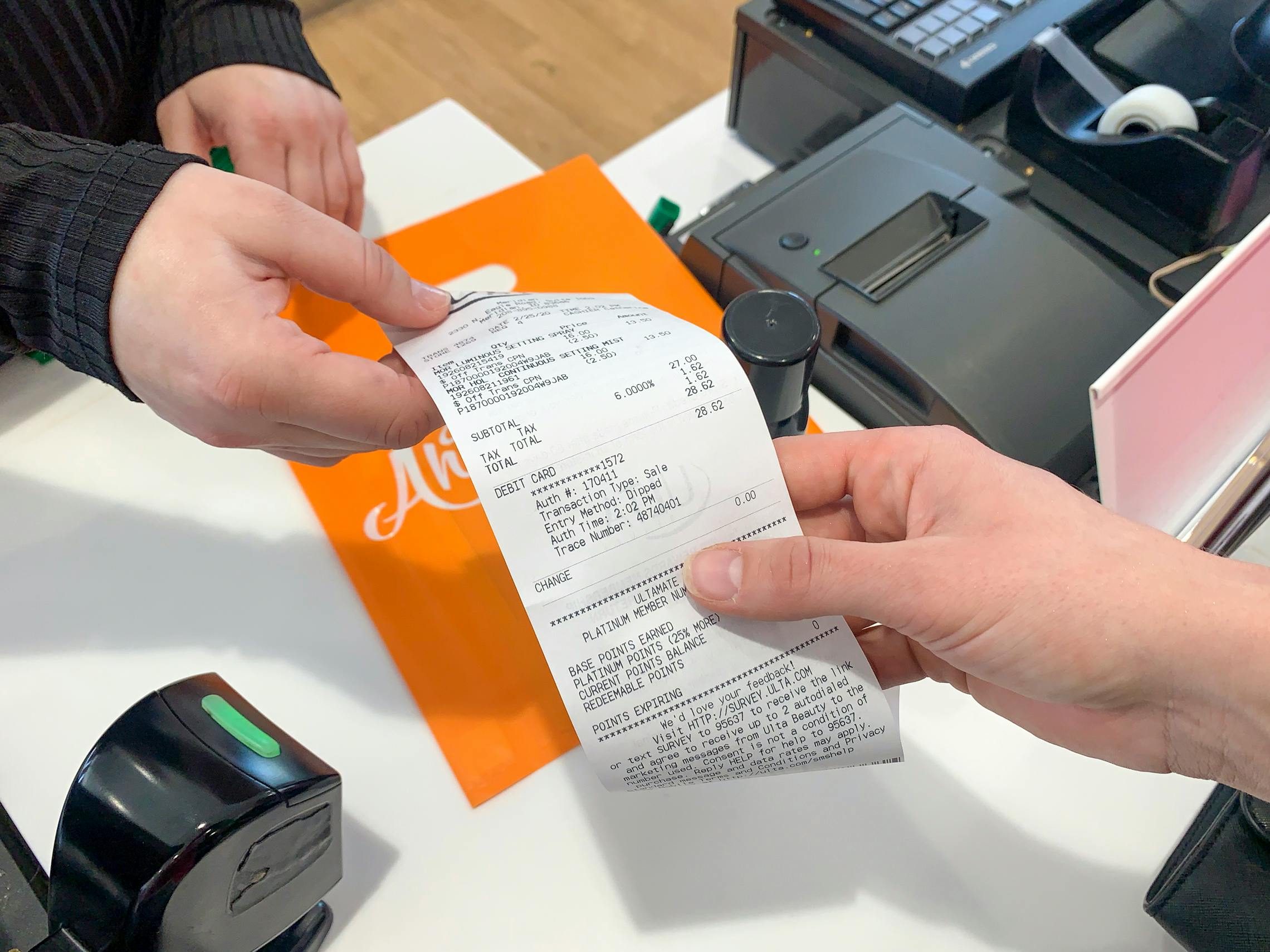 An employee handing a receipt to a customer at checkout.
