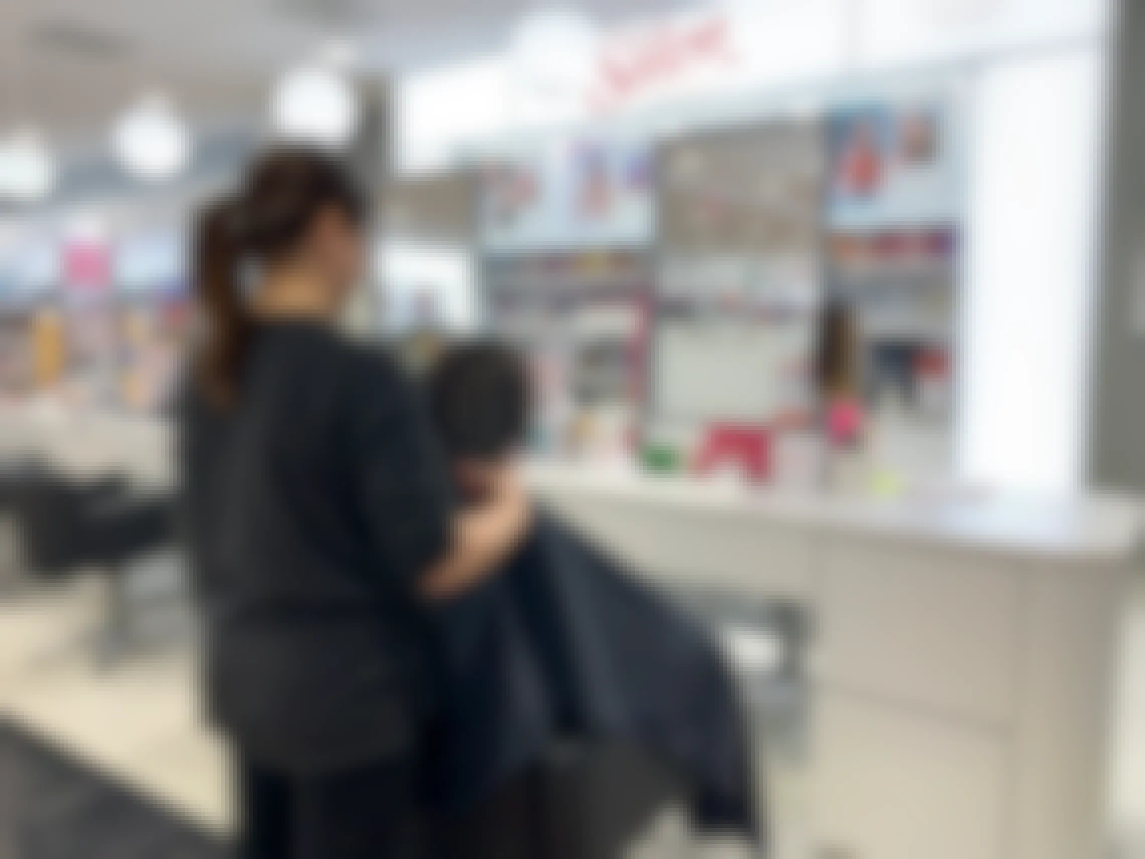 A cosmetologist standing behind a customers chair in the Ulta Salon.