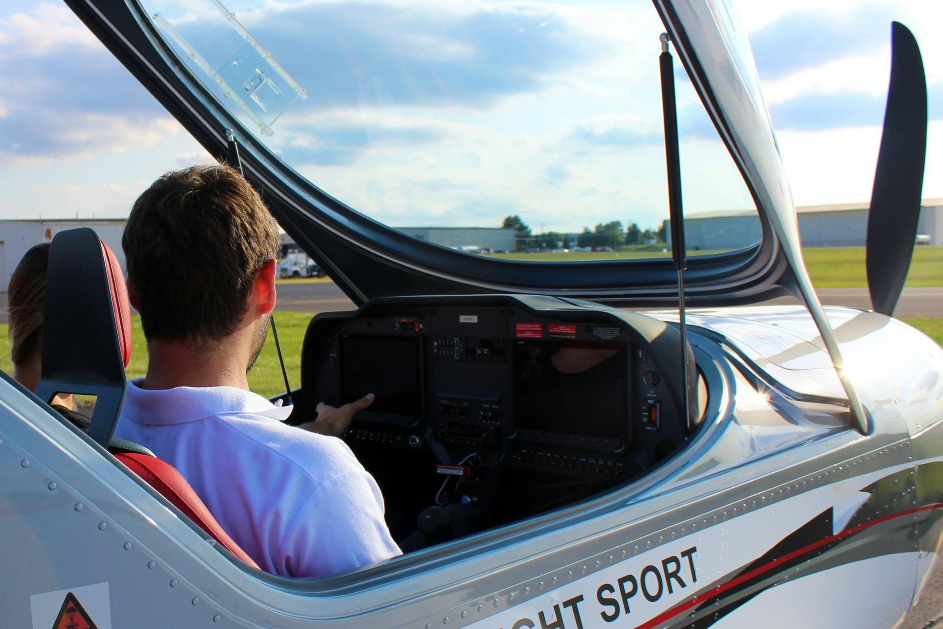 A flight instructor giving instruction to student in a plane.