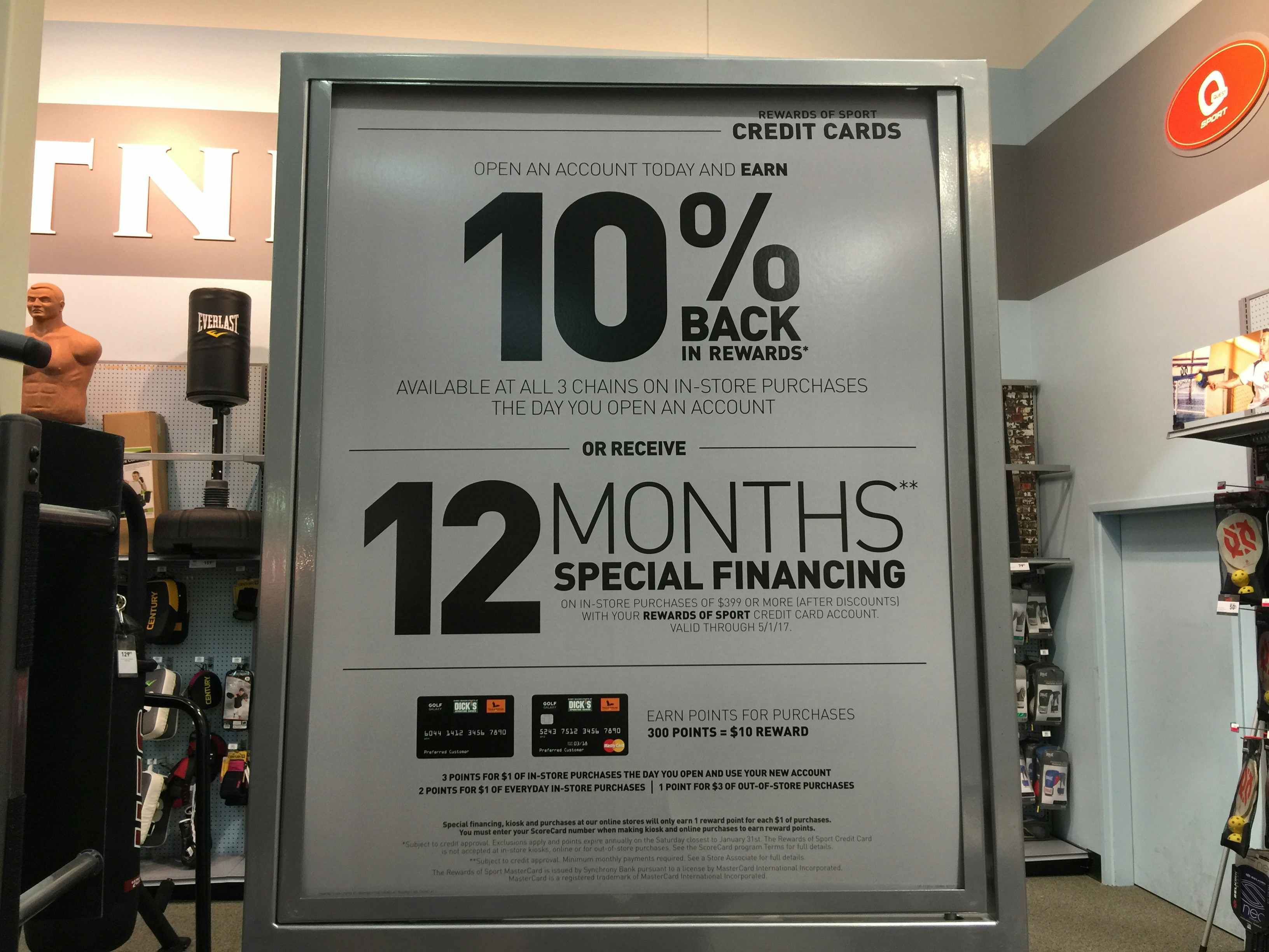 A sign inside Dick's Sporting Goods advertising their credit card perks, including 10% back in rewards, and 12 months special financing.