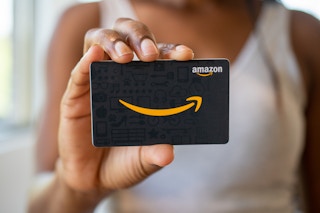 A woman holding an Amazon gift card.