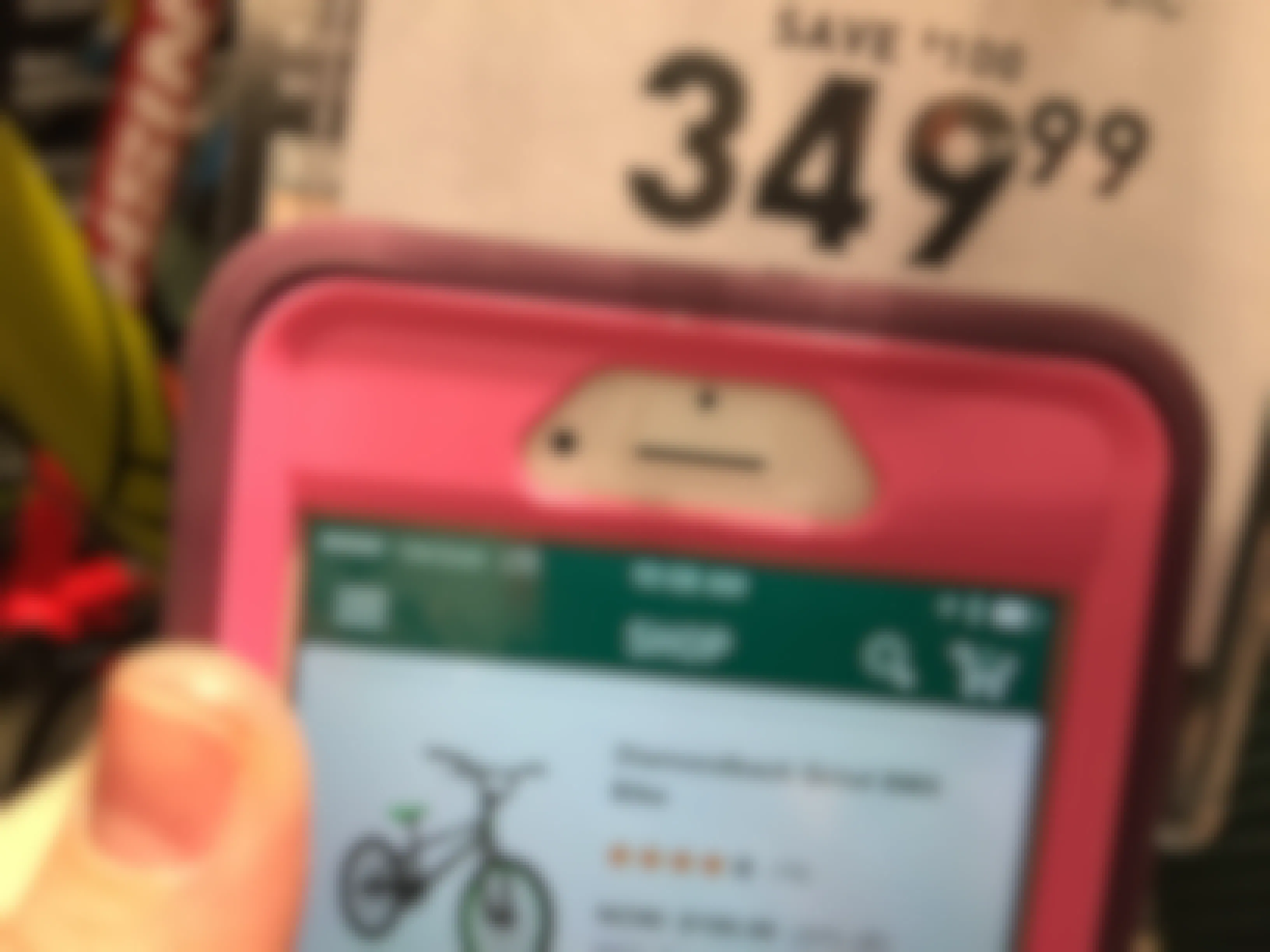 A close up of a price tag on a bike with a lower price pulled up on the Dick's app for the same item.