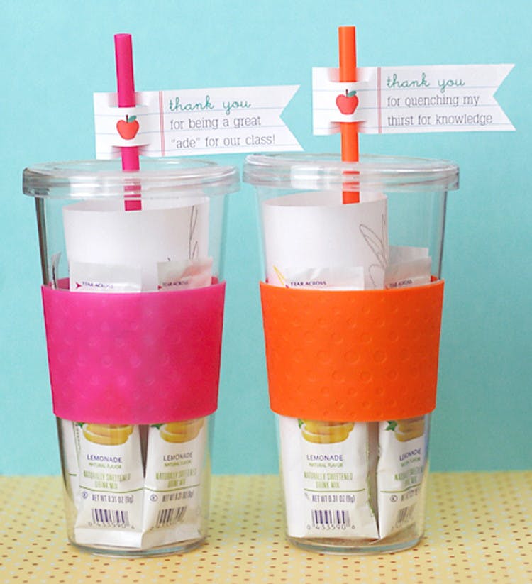 Two clear cups with lemonade drink packets inside along with a straw that has a tag that reads thank you to the teacher.