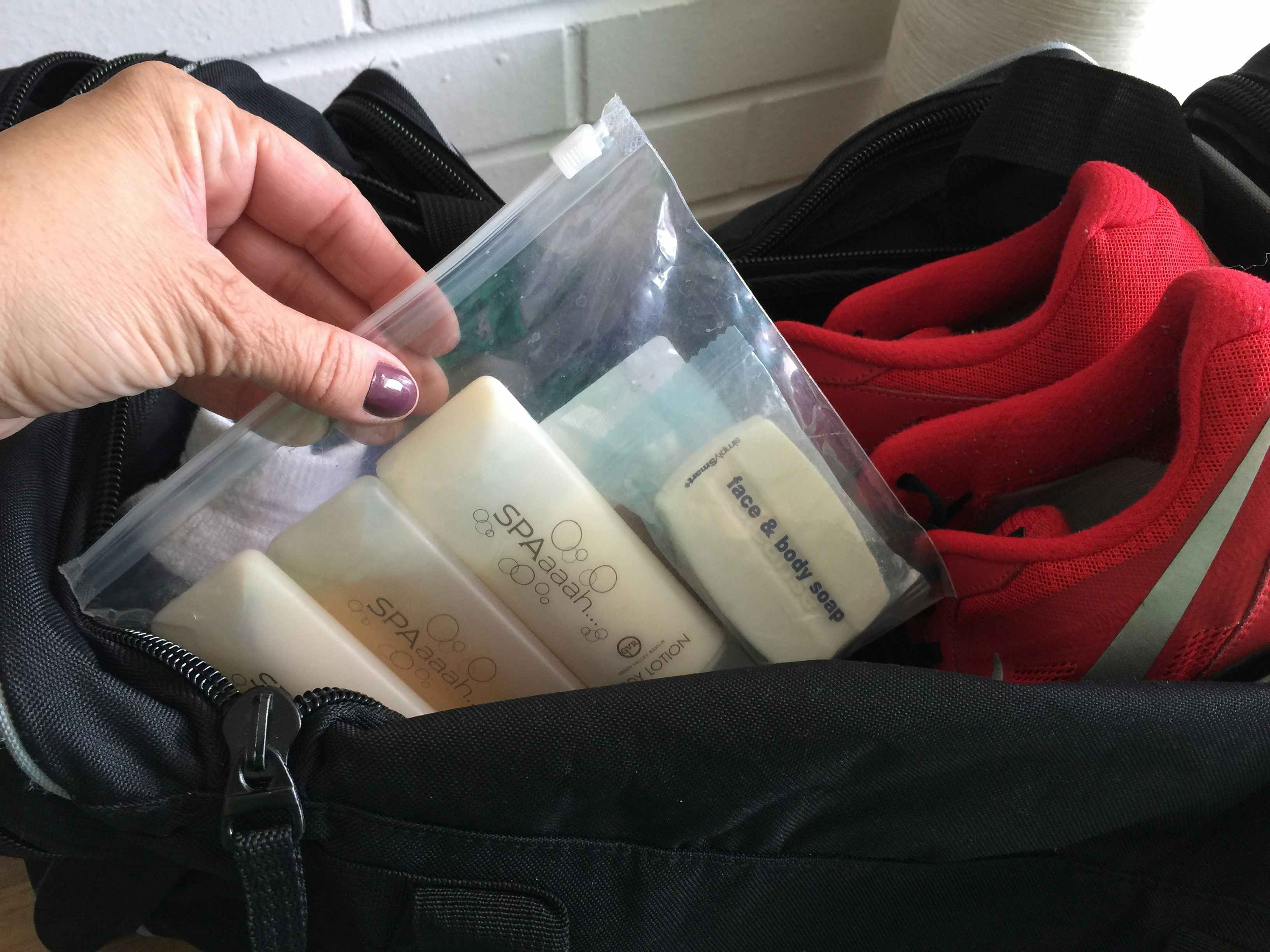 A person holding a bag with toiletries in it.