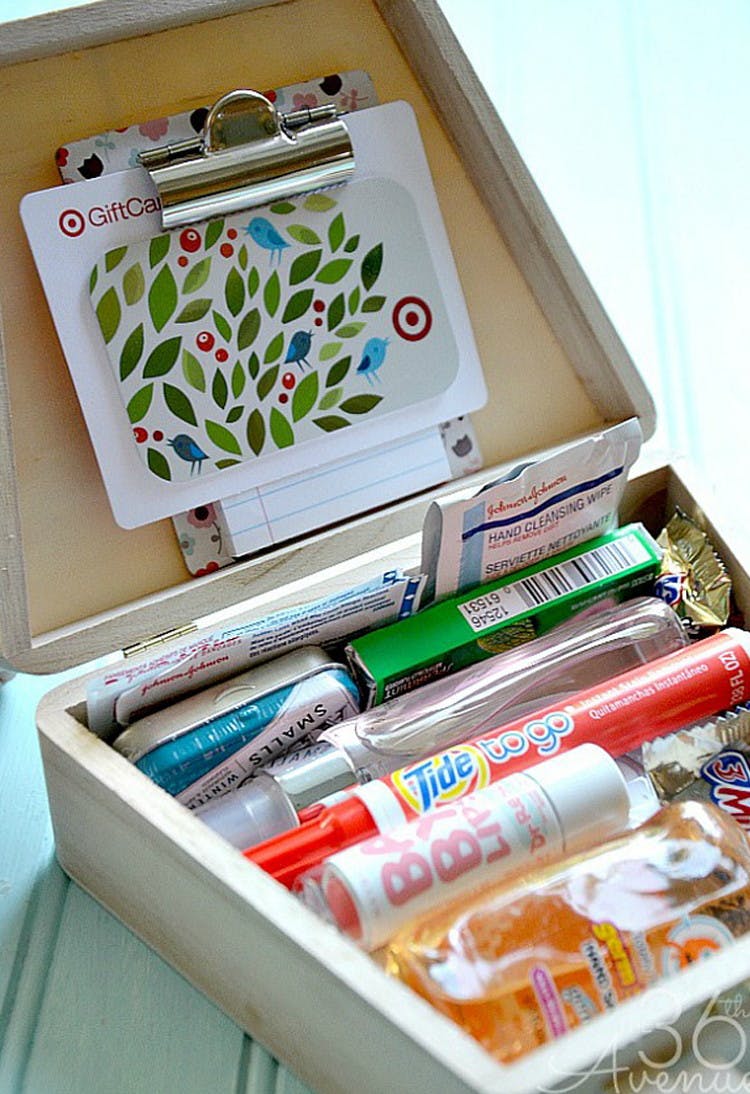 A box with a Tide pen to-go, lip balm, hand sanitizer, gum, band-aids, mints, candy, and a gift card.