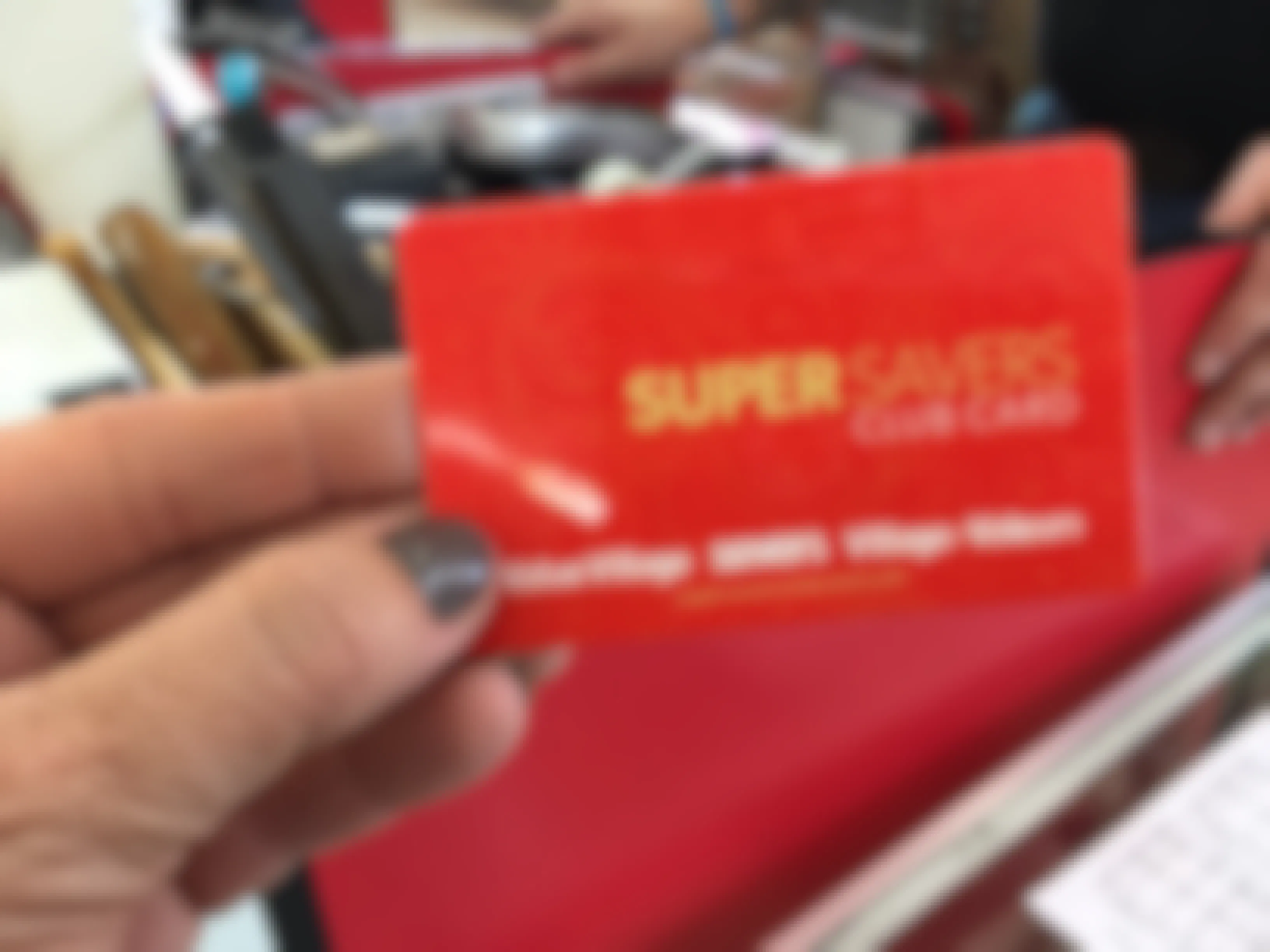 A person holding a Super Savers card in a Value Village thrift store