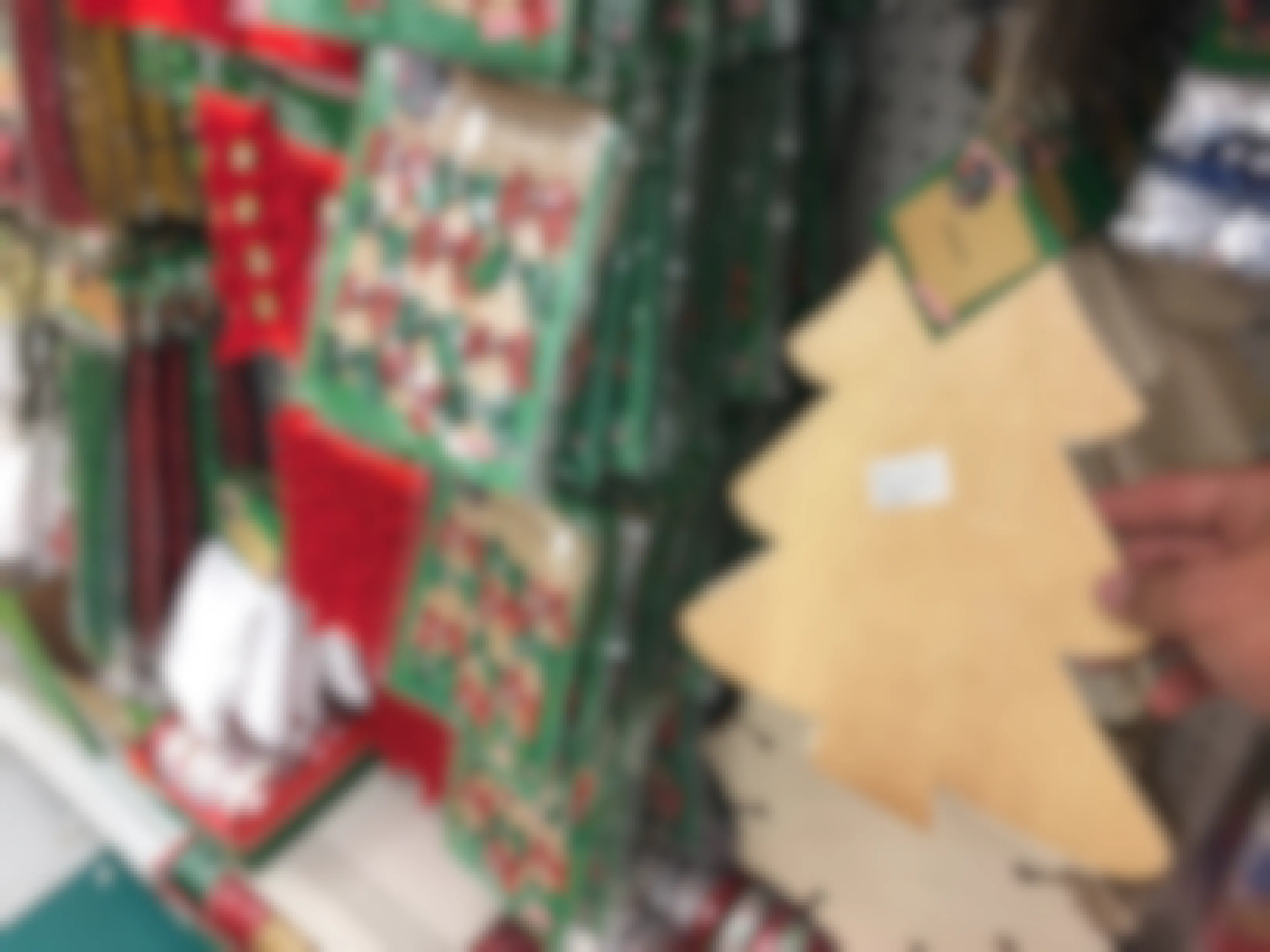somone holding tree decoration next to Christmas decorations at Dollar Tree