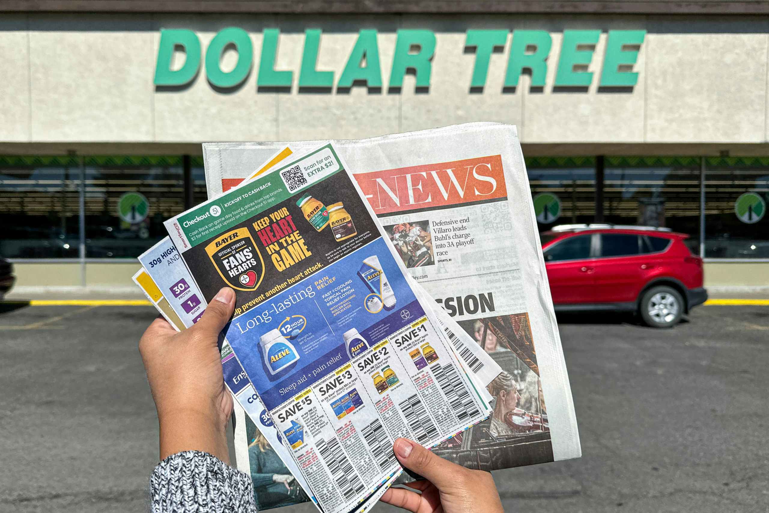 a person holding a newspaper outside dollar tree