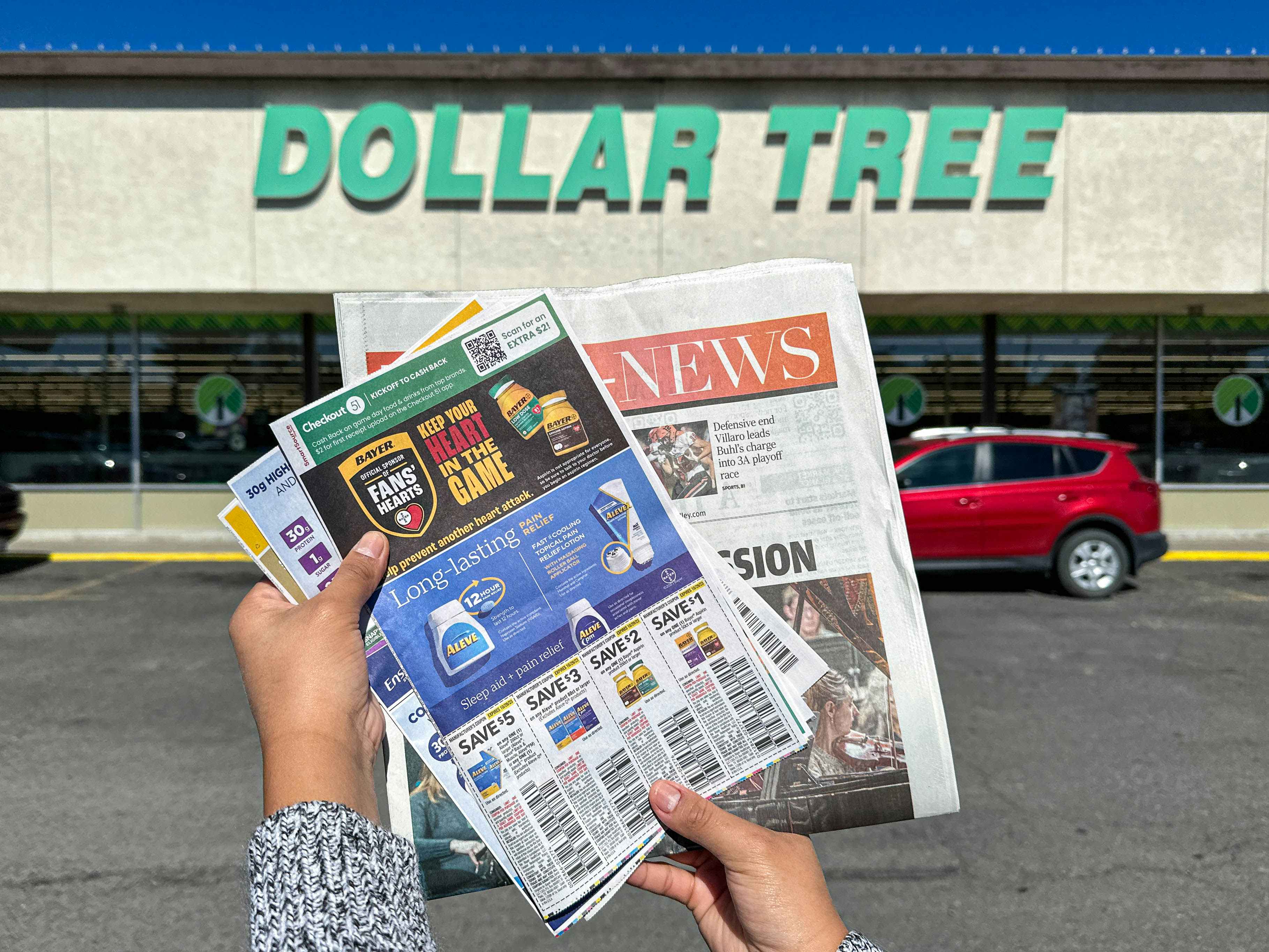 a person holding a newspaper outside dollar tree 