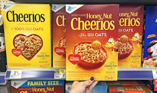 Hand holding a box of Honey Nut Cheerios in a store