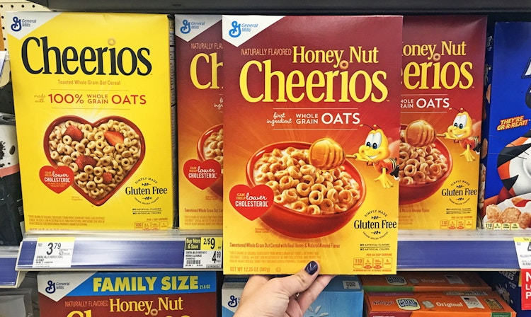 Hand holding a box of Honey Nut Cheerios in a store