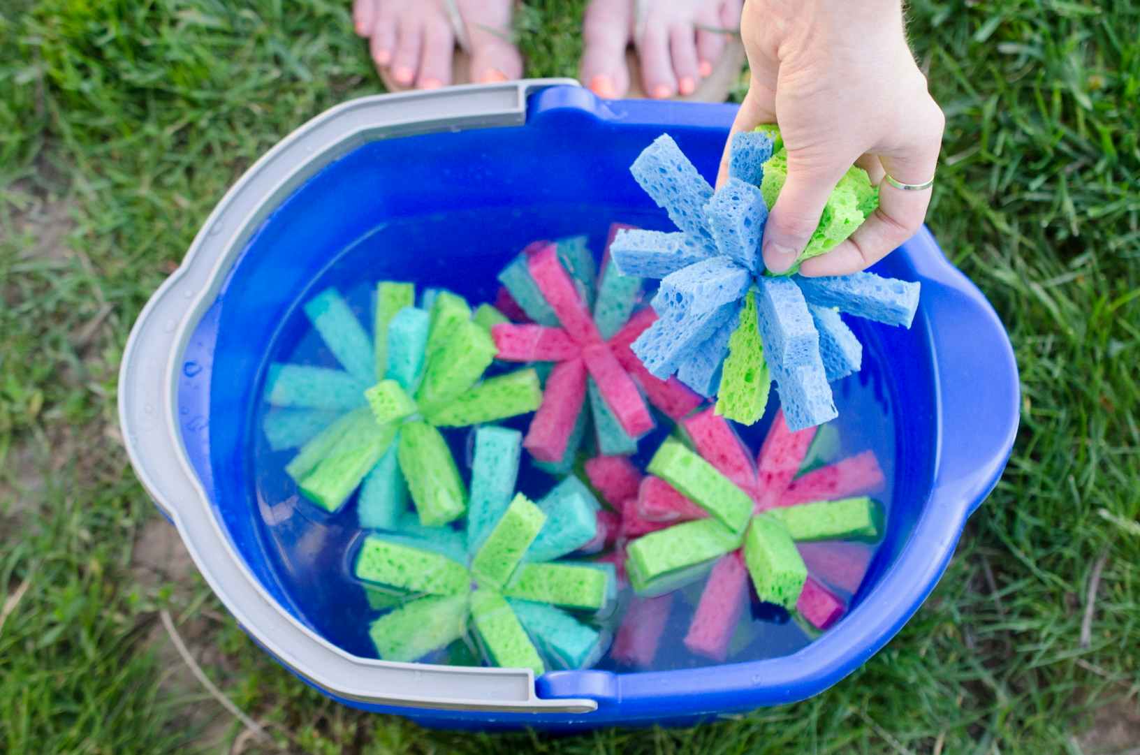 A bucket of sponges that have been cut to look like balls in a bucket of water.