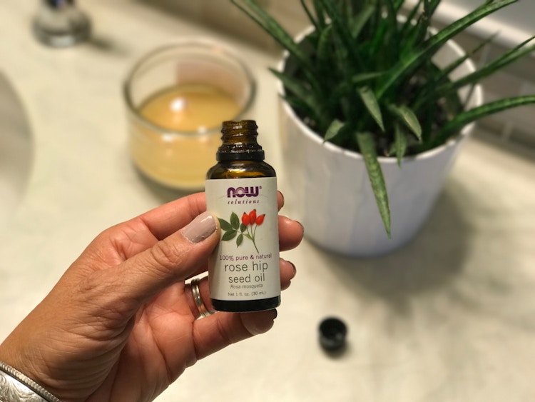 Someone holding a bottle of rose hip seed oil