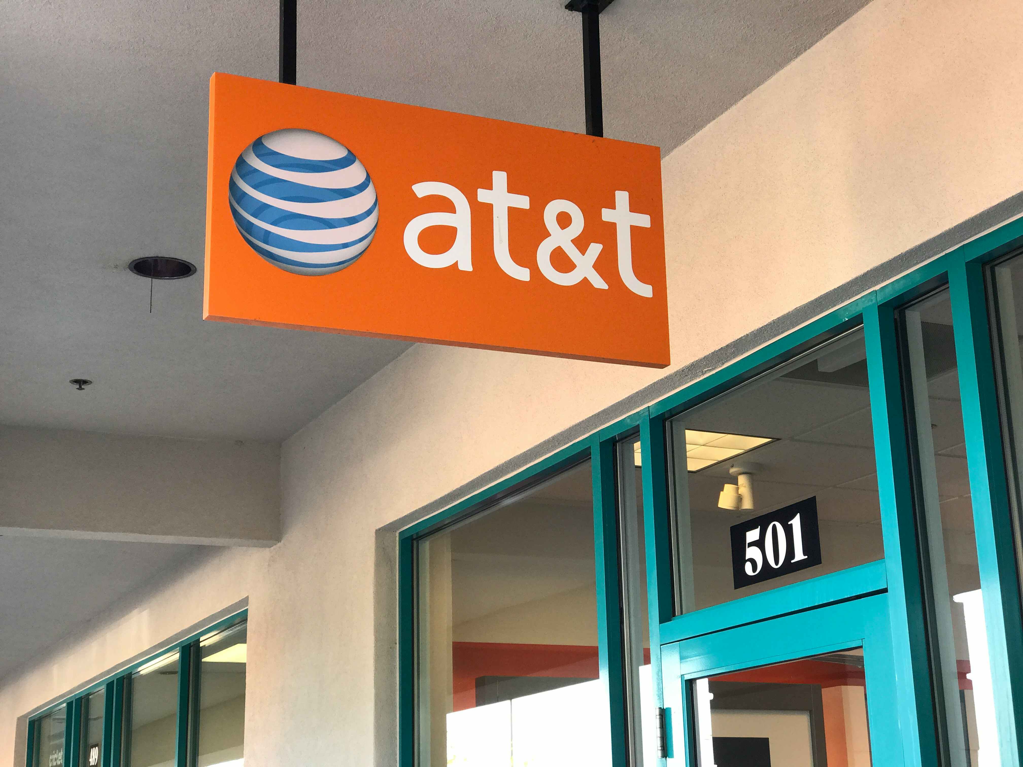 A hanging sign for AT&T outside an AT&T store.