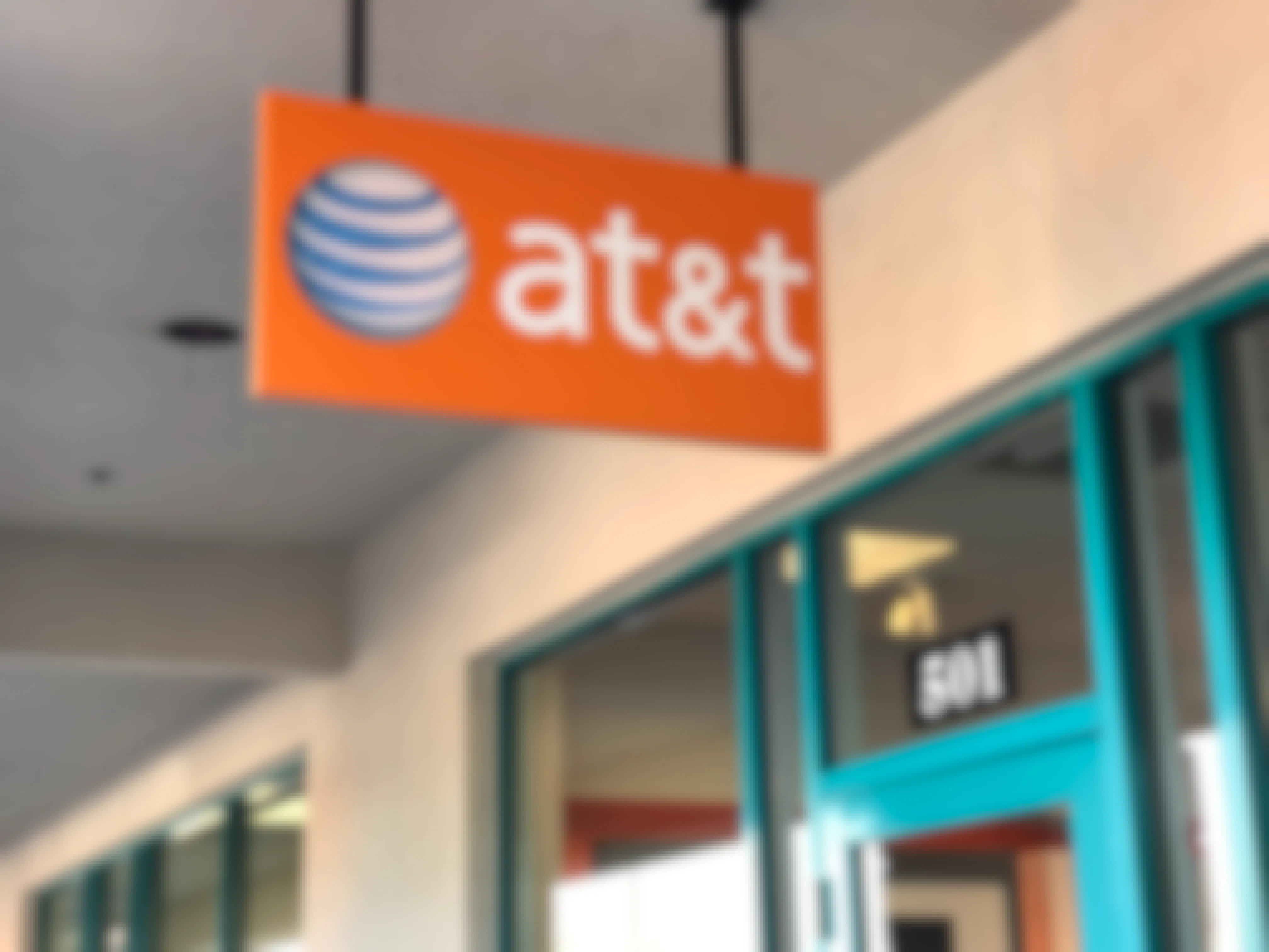 A hanging sign for AT&T outside an AT&T store.