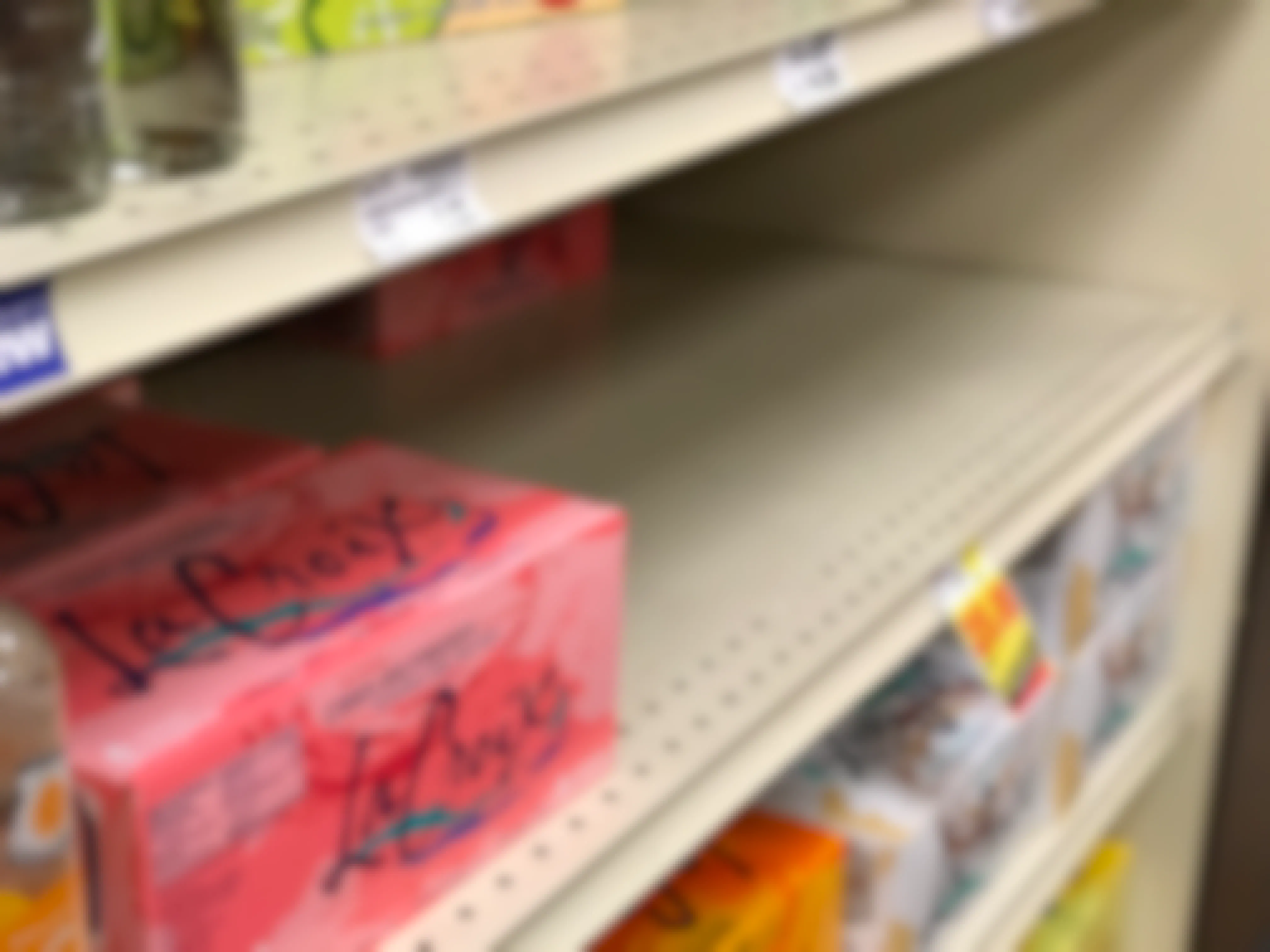 An almost empty shelf of La Croix sparkling water.