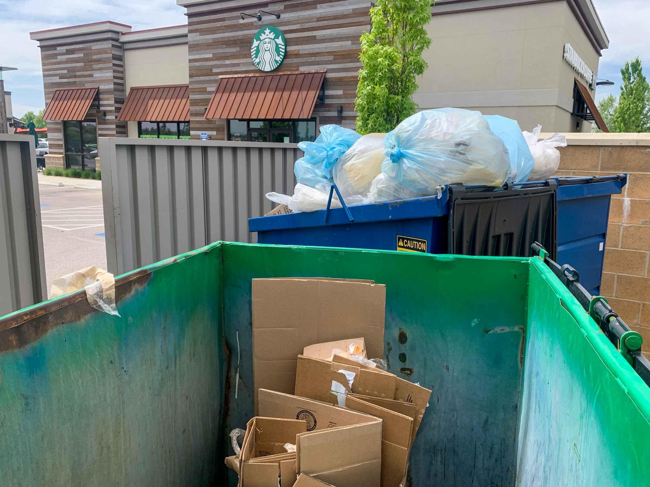 Cardboard boxes in recycle dumpster outside Starbucks.