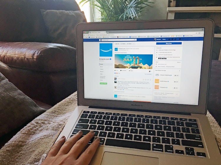 Someone on their laptop looking on facebook at amazons profile