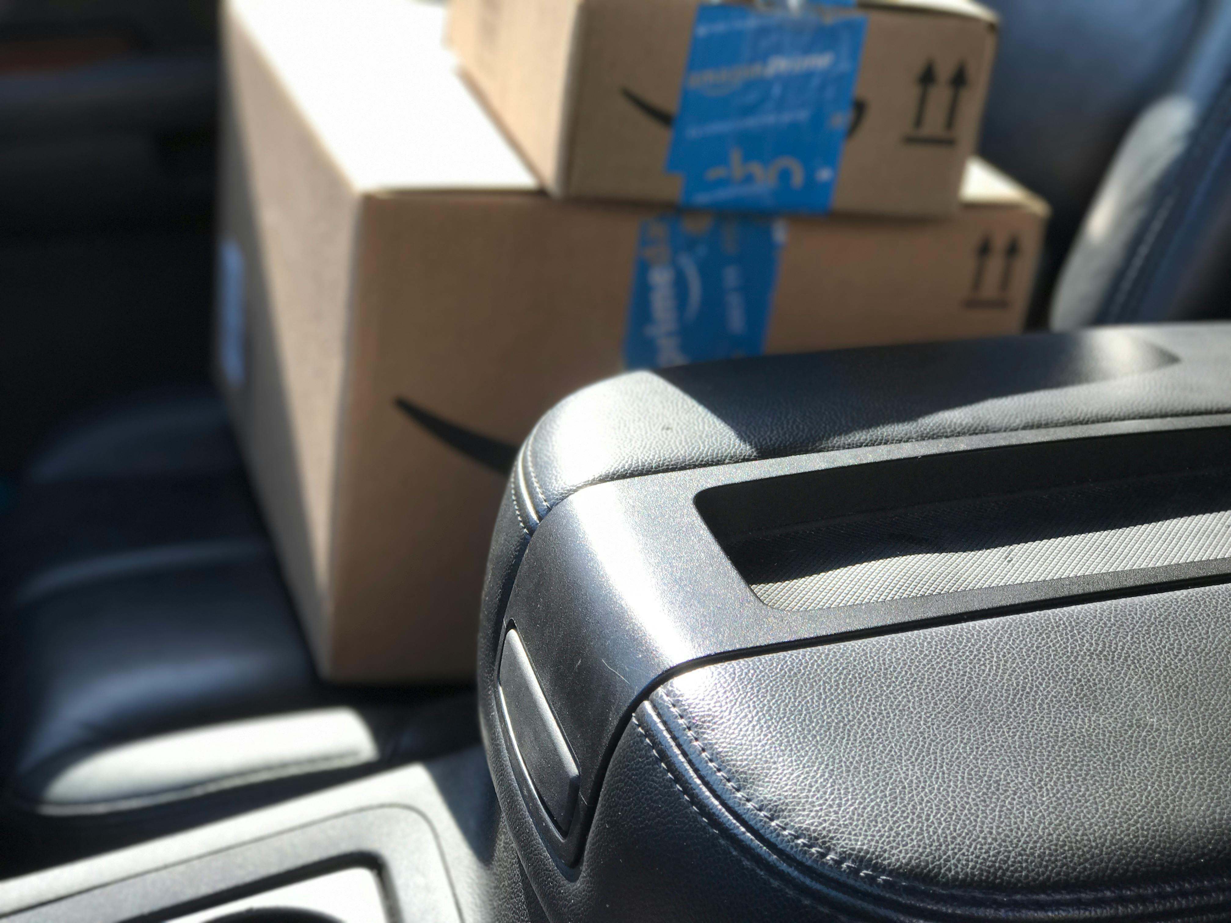 Two Amazon packages in the passenger seat of a vehicle.