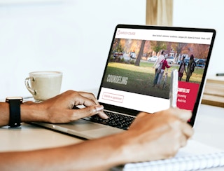 A student using a laptop to go on the Antioch College website.