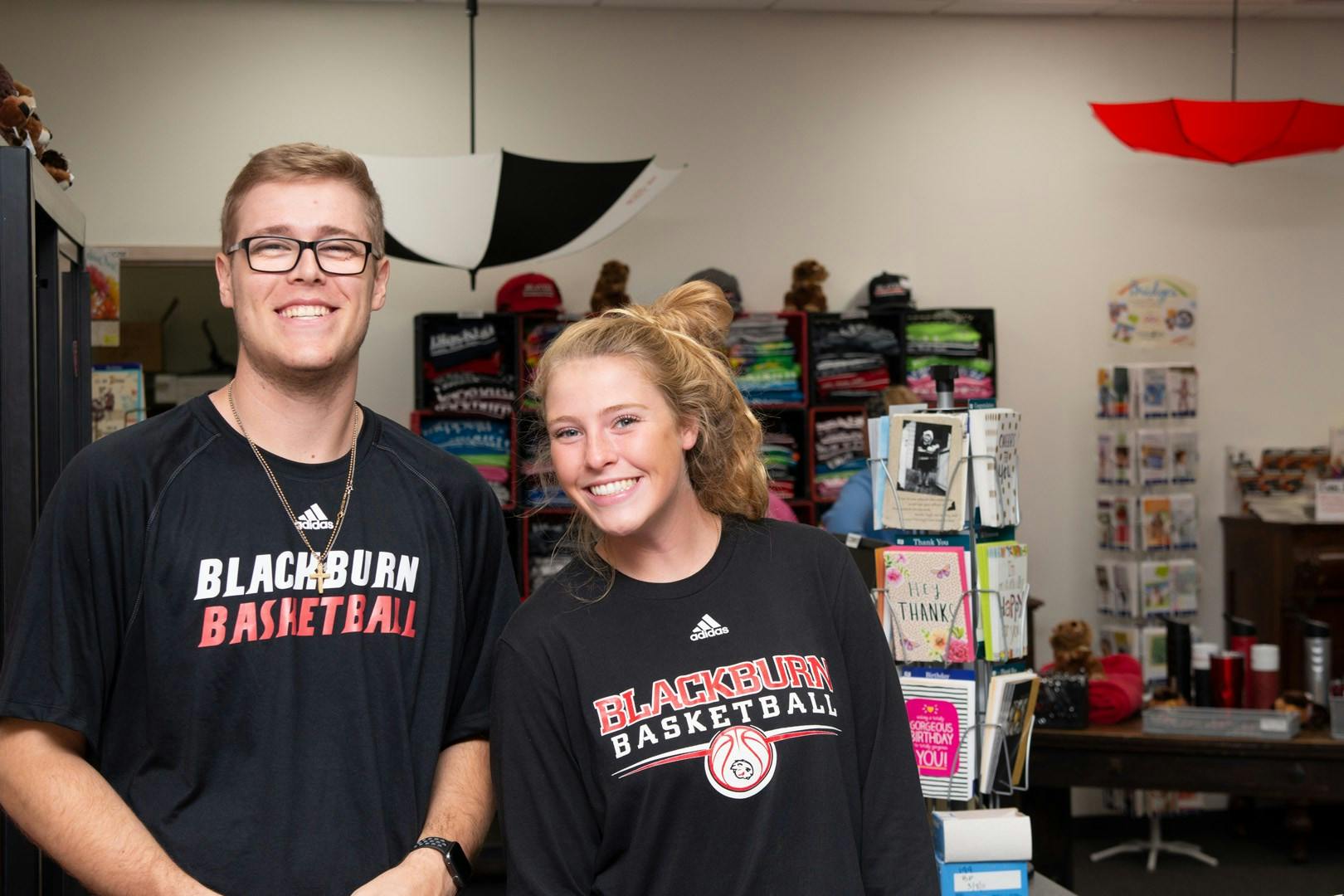 Two students wearing Blackburn College Basketball shirts.