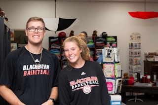 Two students wearing Blackburn College Basketball shirts.