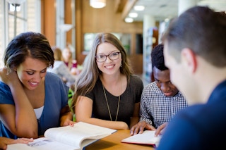 Students at College of the Ozarks studying at a table in a library.