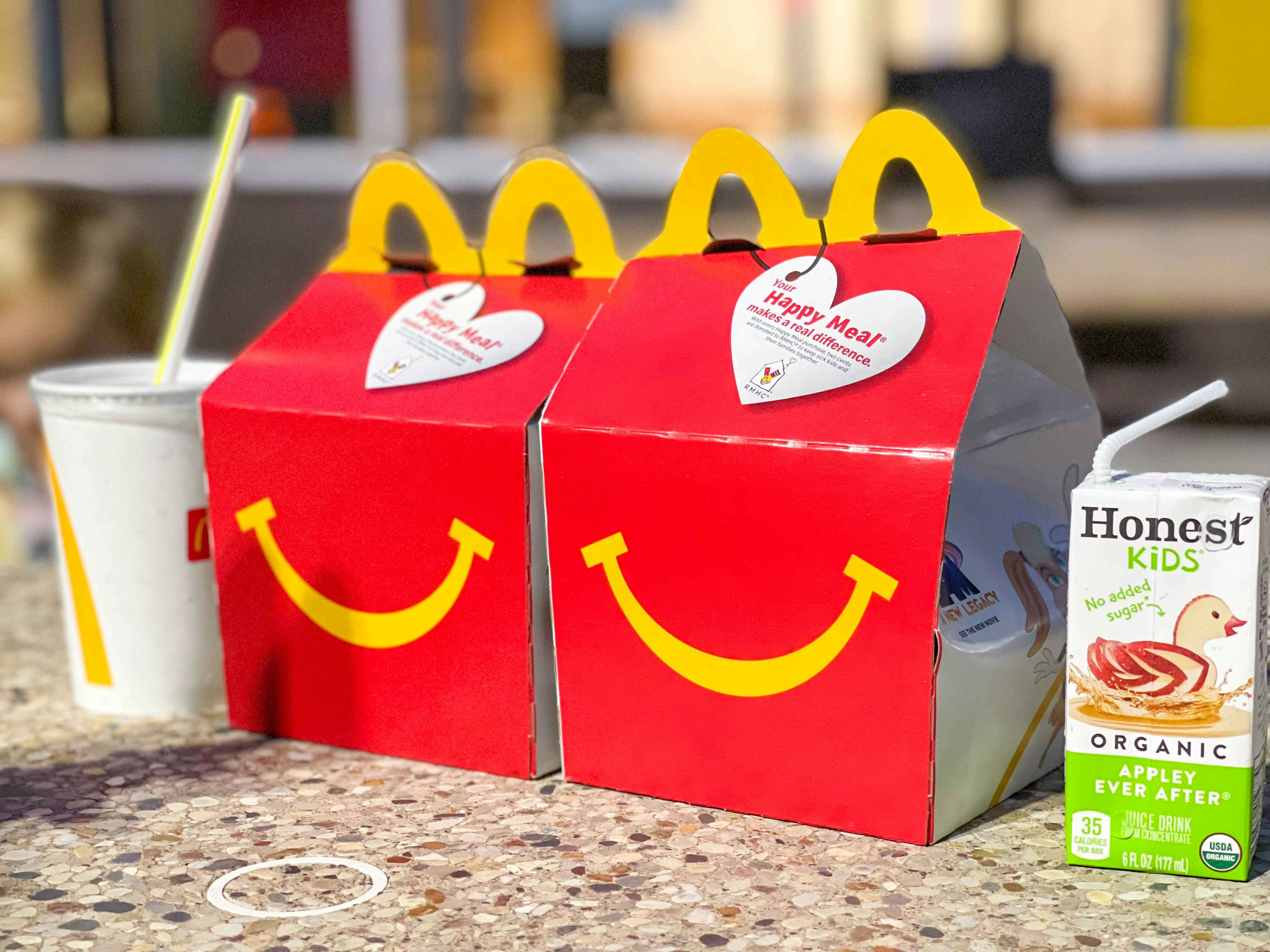 two mcdonalds happy meals on table with drinks