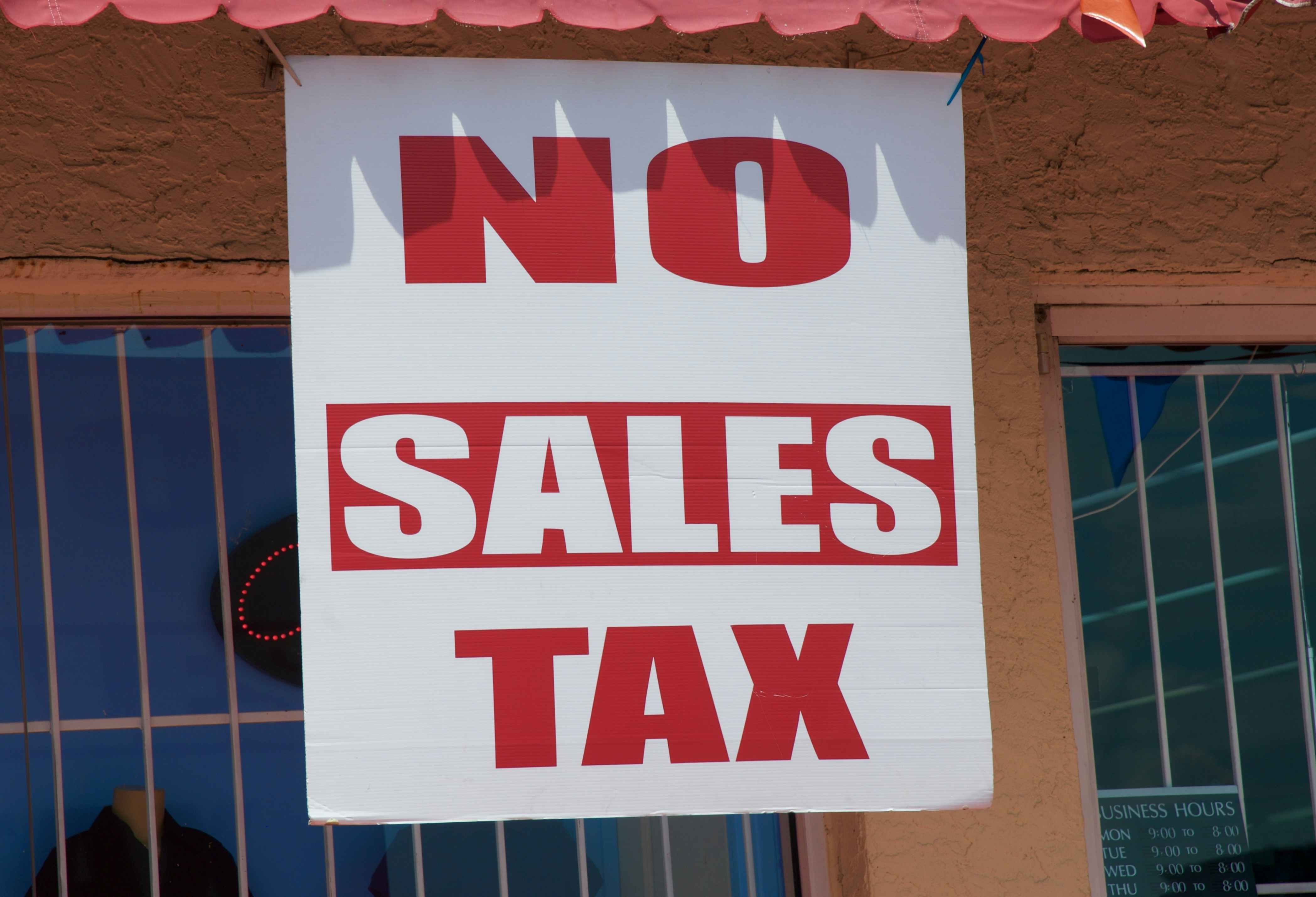 Large no sales tax sign hanging in front of a store
