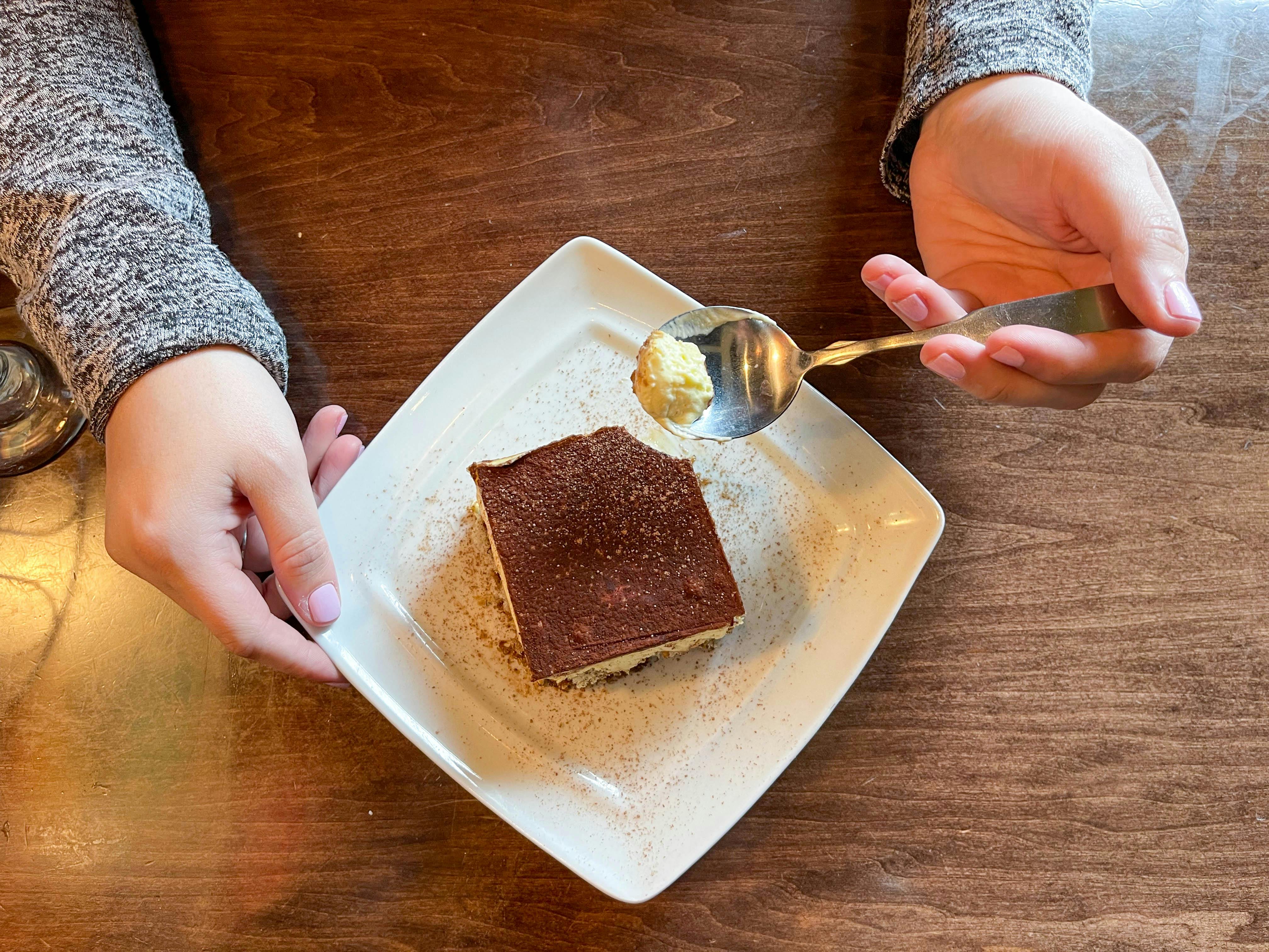 a plate of dessert with a person holding a spoon 