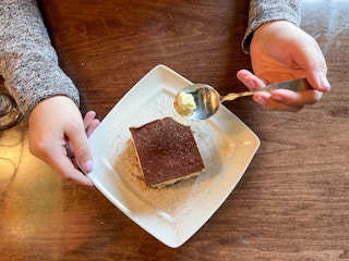 a plate of dessert with a person holding a spoon