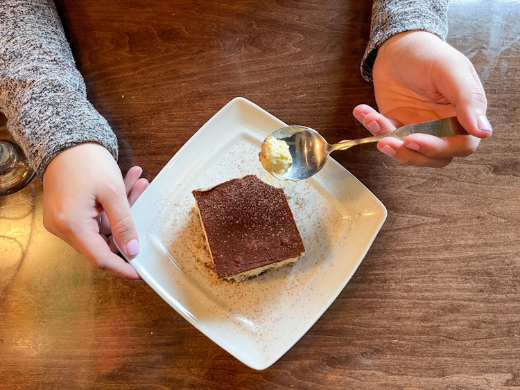 a plate of dessert with a person holding a spoon 