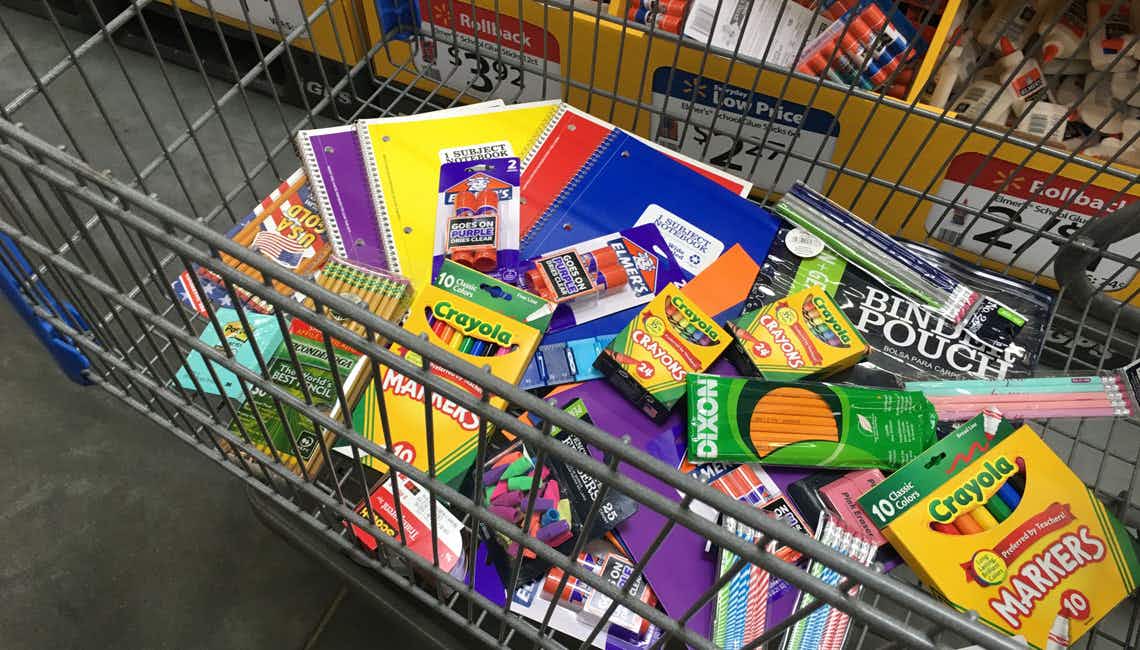Walmart grocery cart full of school supplies like glue, Crayola, pencils and more.