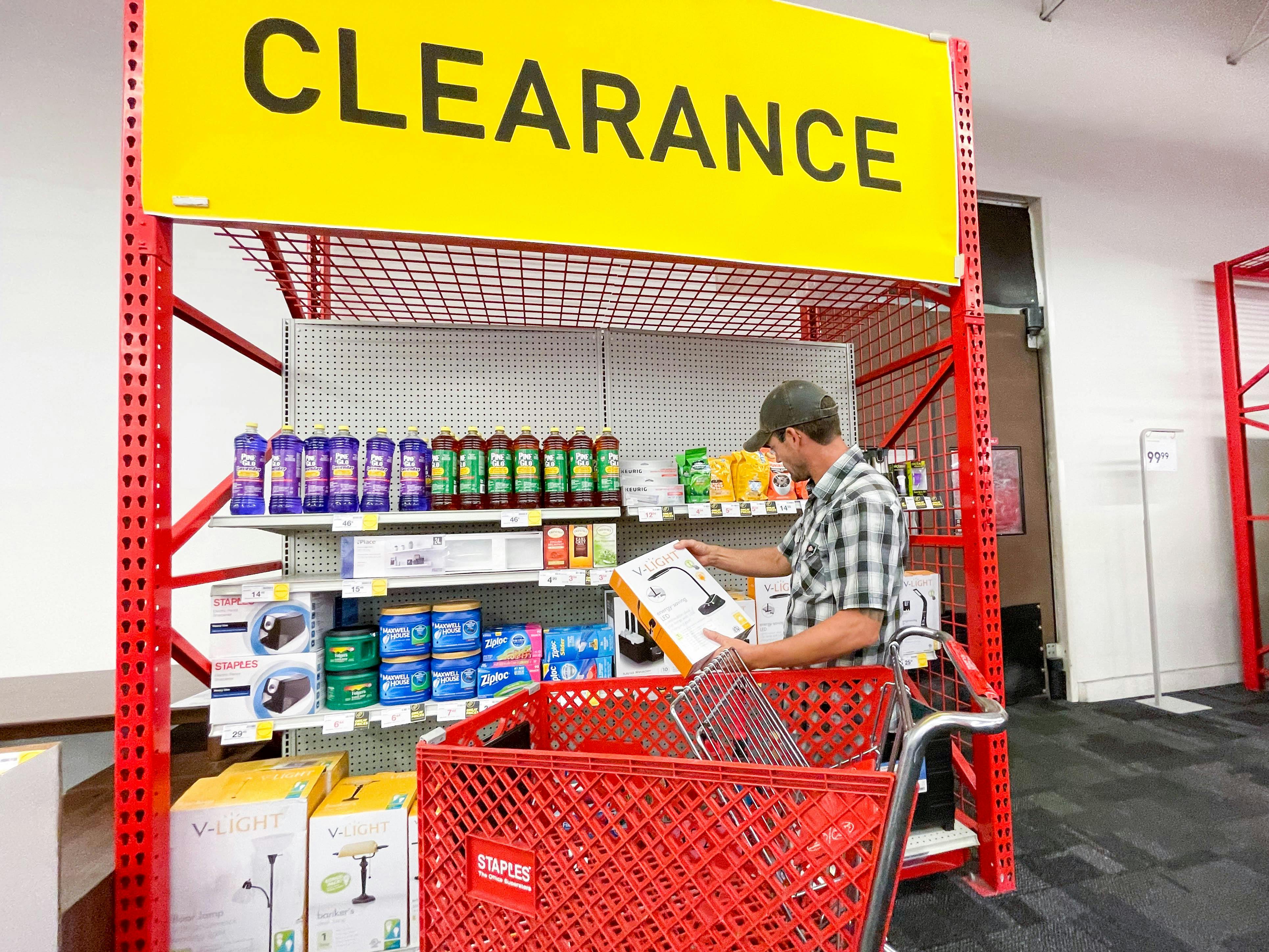 A man with a Staples shopping cart looking through the clearance shelf at Staples.