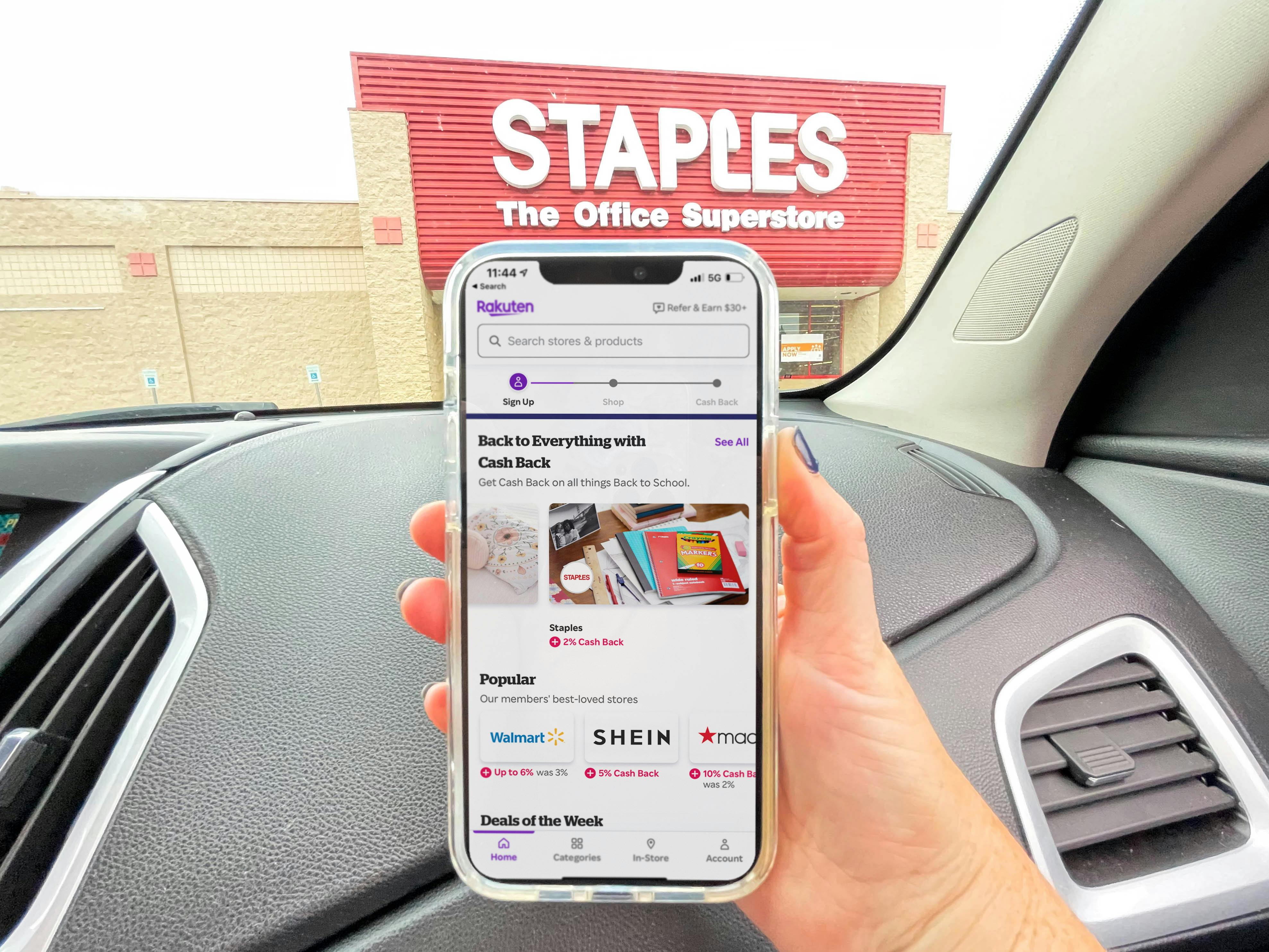 cellphone being help up in car with rakuten app in front of staples