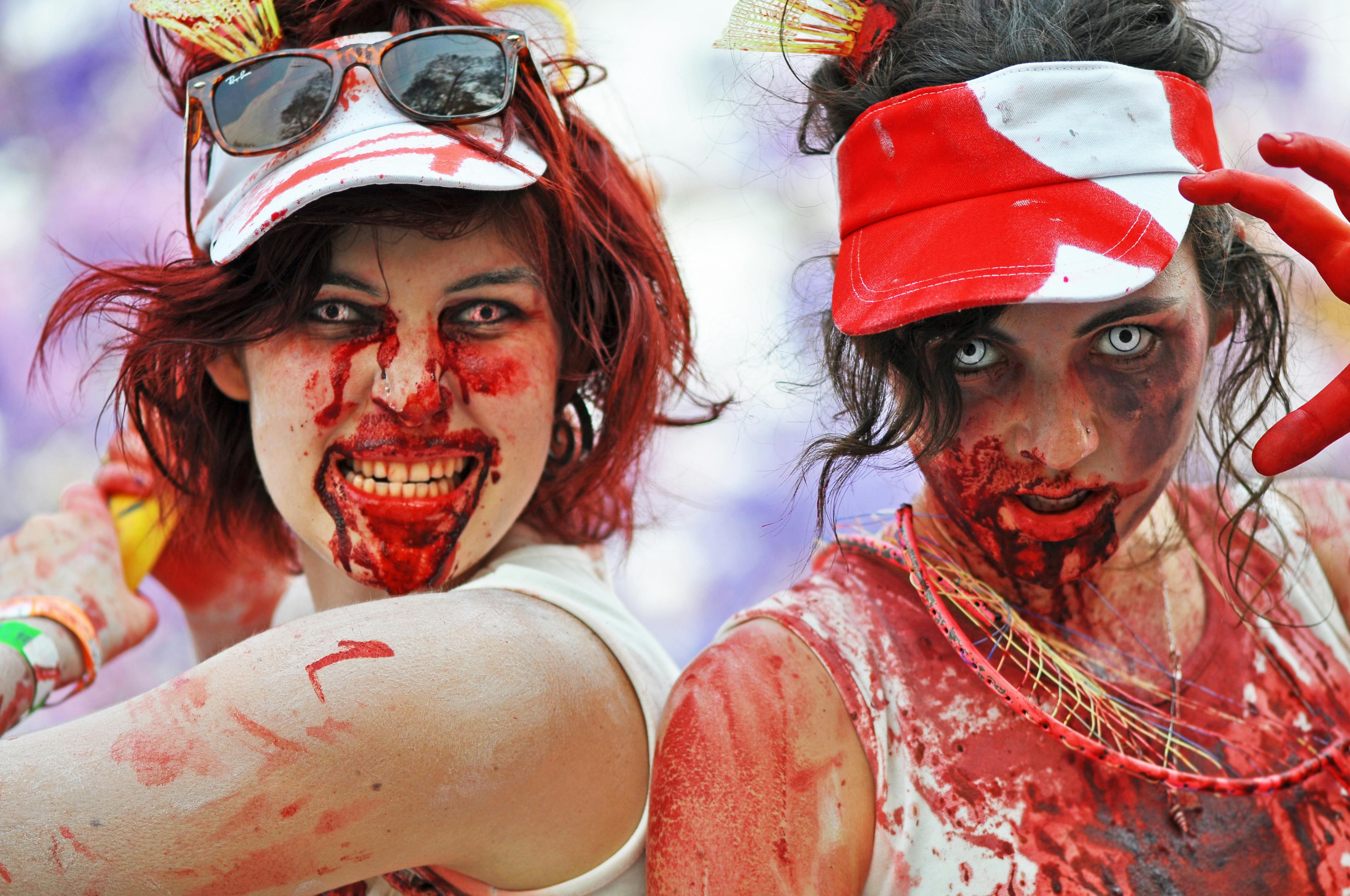 Two women dressed up as zombies, posing for a photo.
