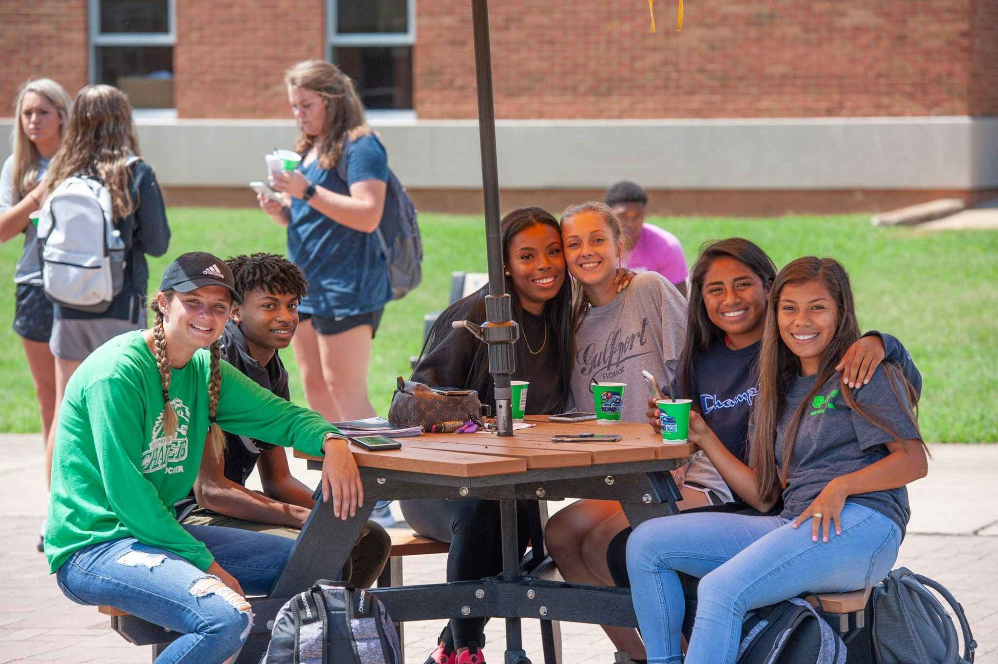 A group of students at Columbia State Community College sitting at a table on campus and smiling.