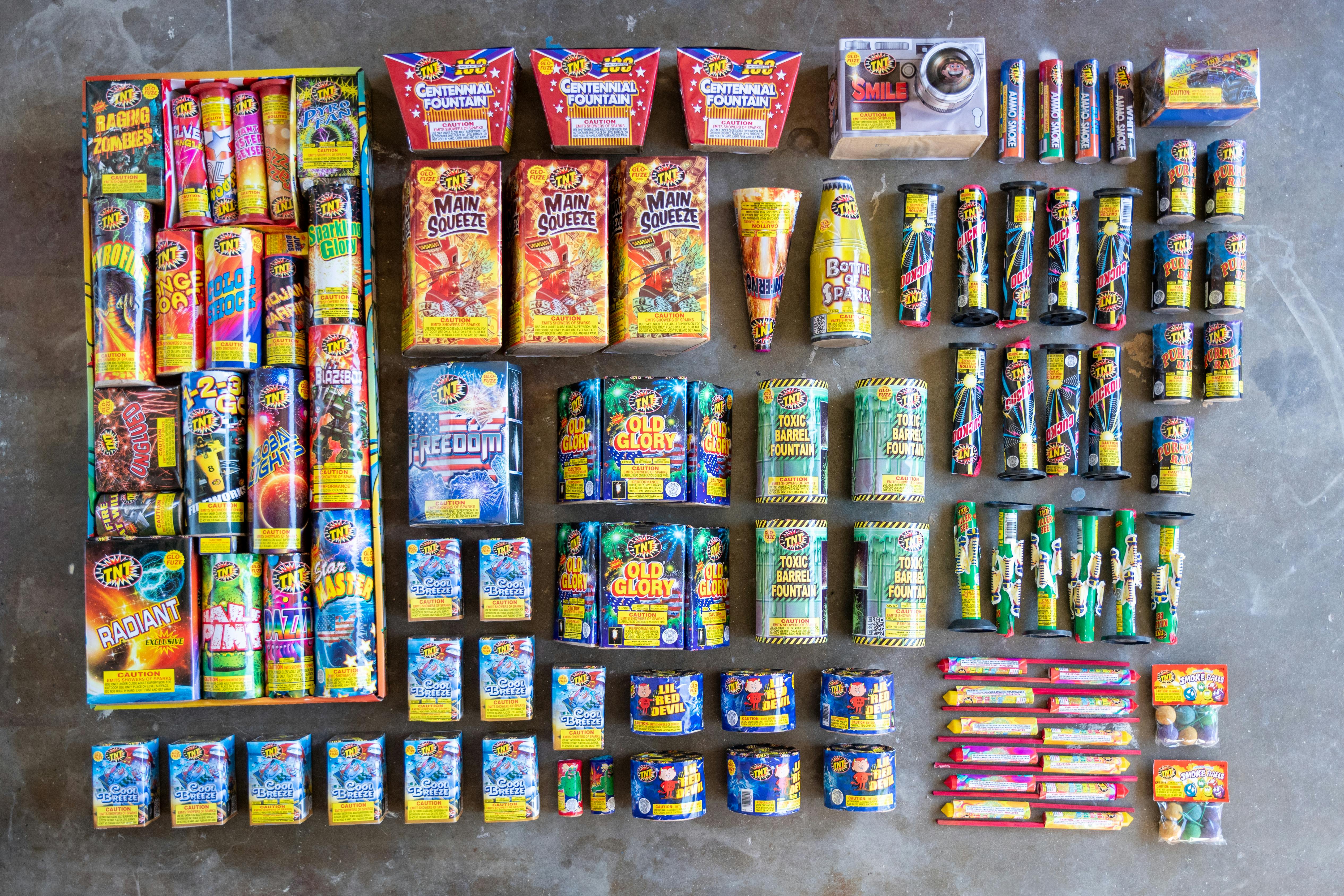 Different kinds of fireworks organized into a display on the ground.
