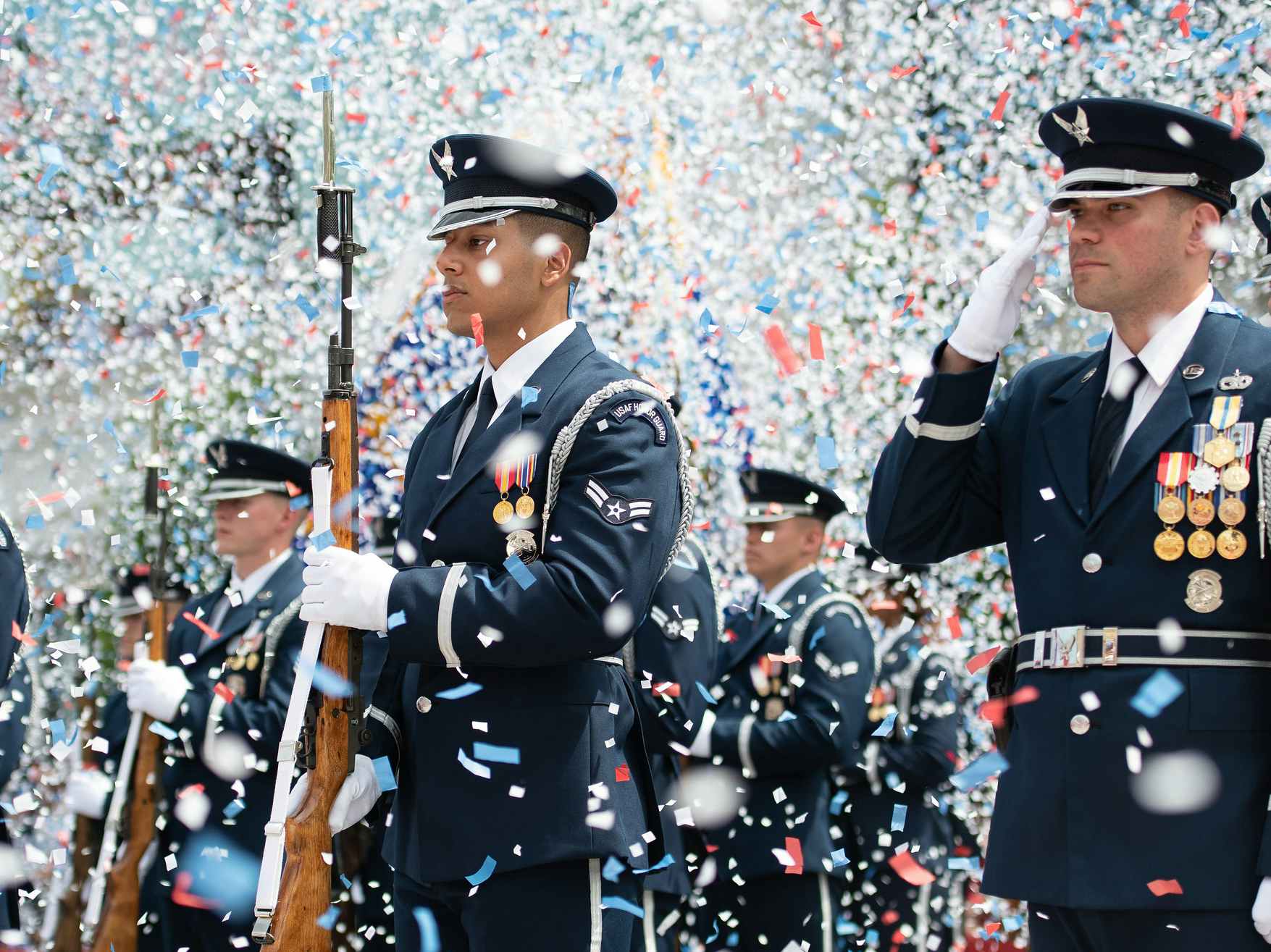 US Air Force soldiers dressed in uniform with confetti flying around them