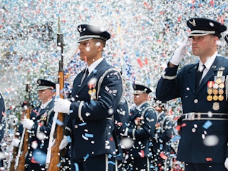US Air Force soldiers dressed in uniform with confetti flying around them