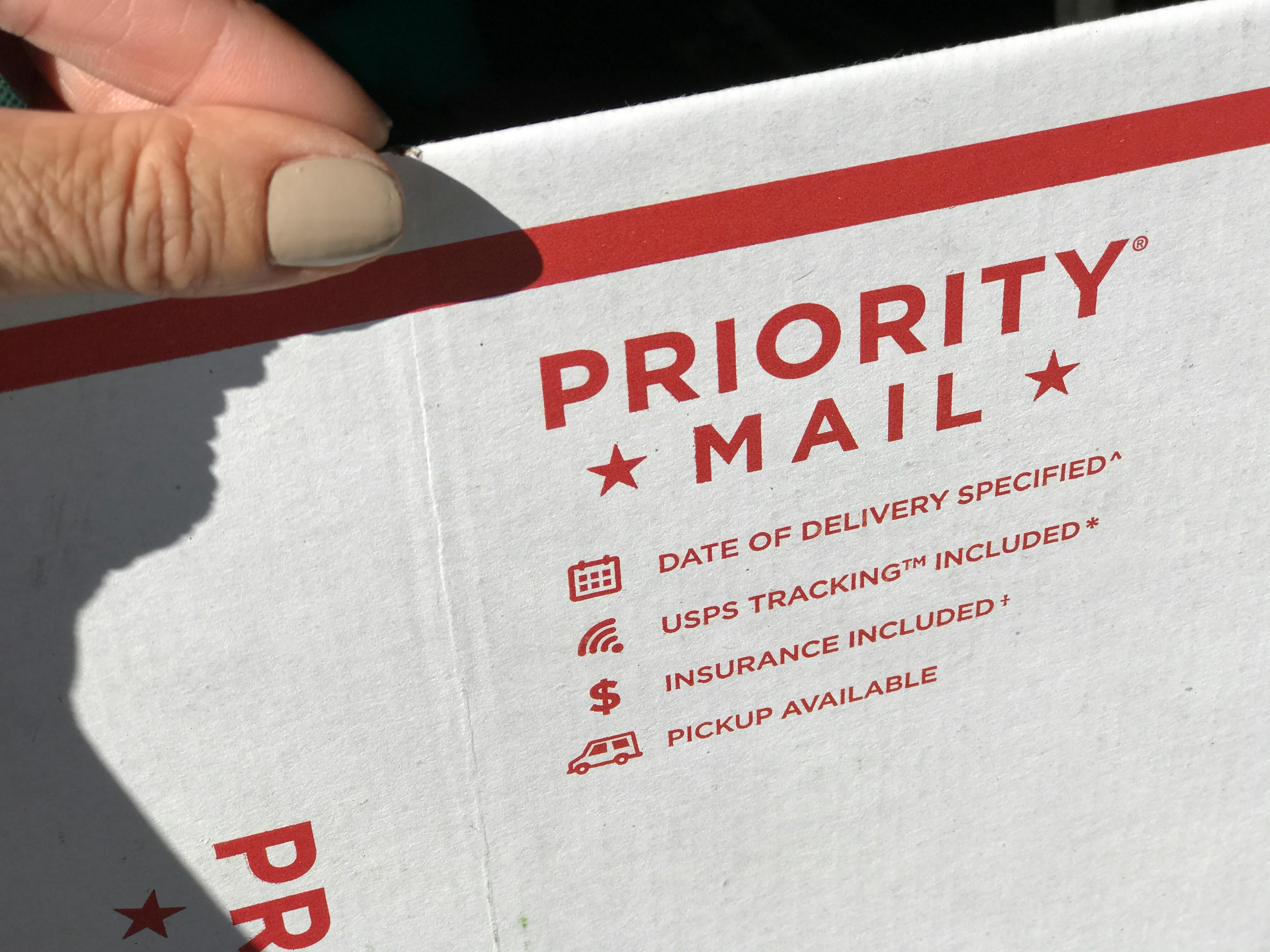 hand holds a priority mail envelope