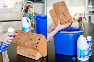 someone using spray duster on knife block next to bucket of water and clorox