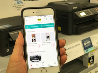 hand holds a phone with the ibotta app open to best buy store