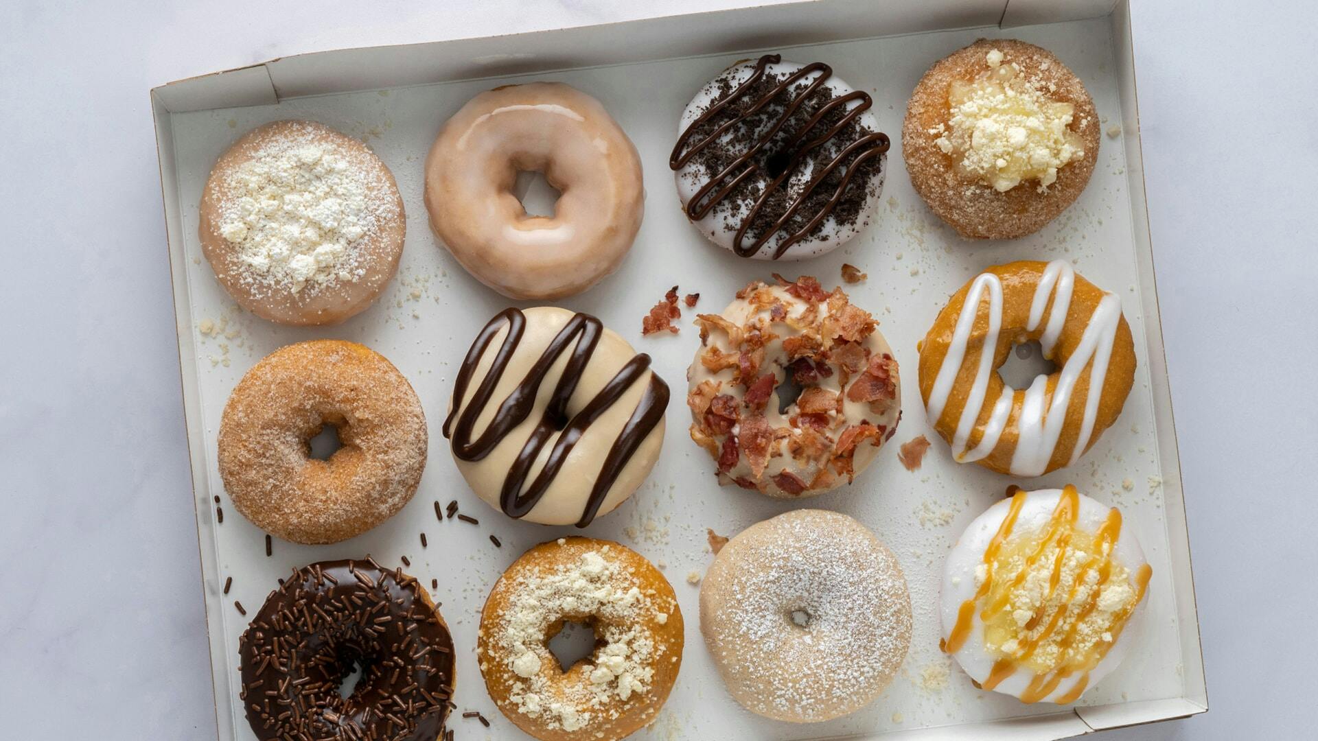 A box containing a dozen of Duck Donuts 